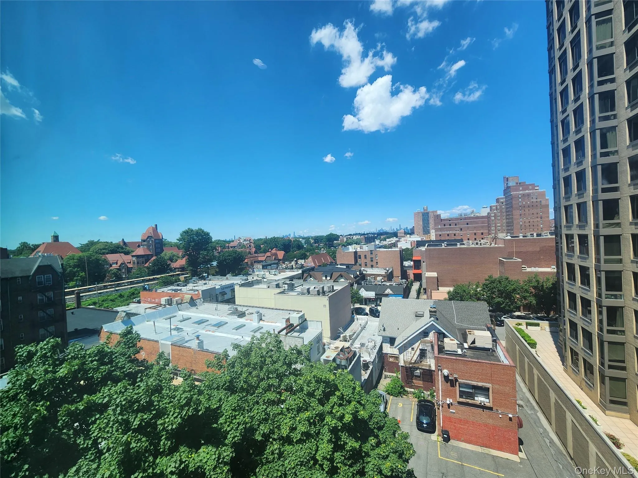 Expansive cityscape panorama featuring diverse architectural styles, abundant mature trees, and a distant elevated railway Expansive cityscape panorama featuring diverse architectural styles, abundant mature trees, and a distant elevated railway