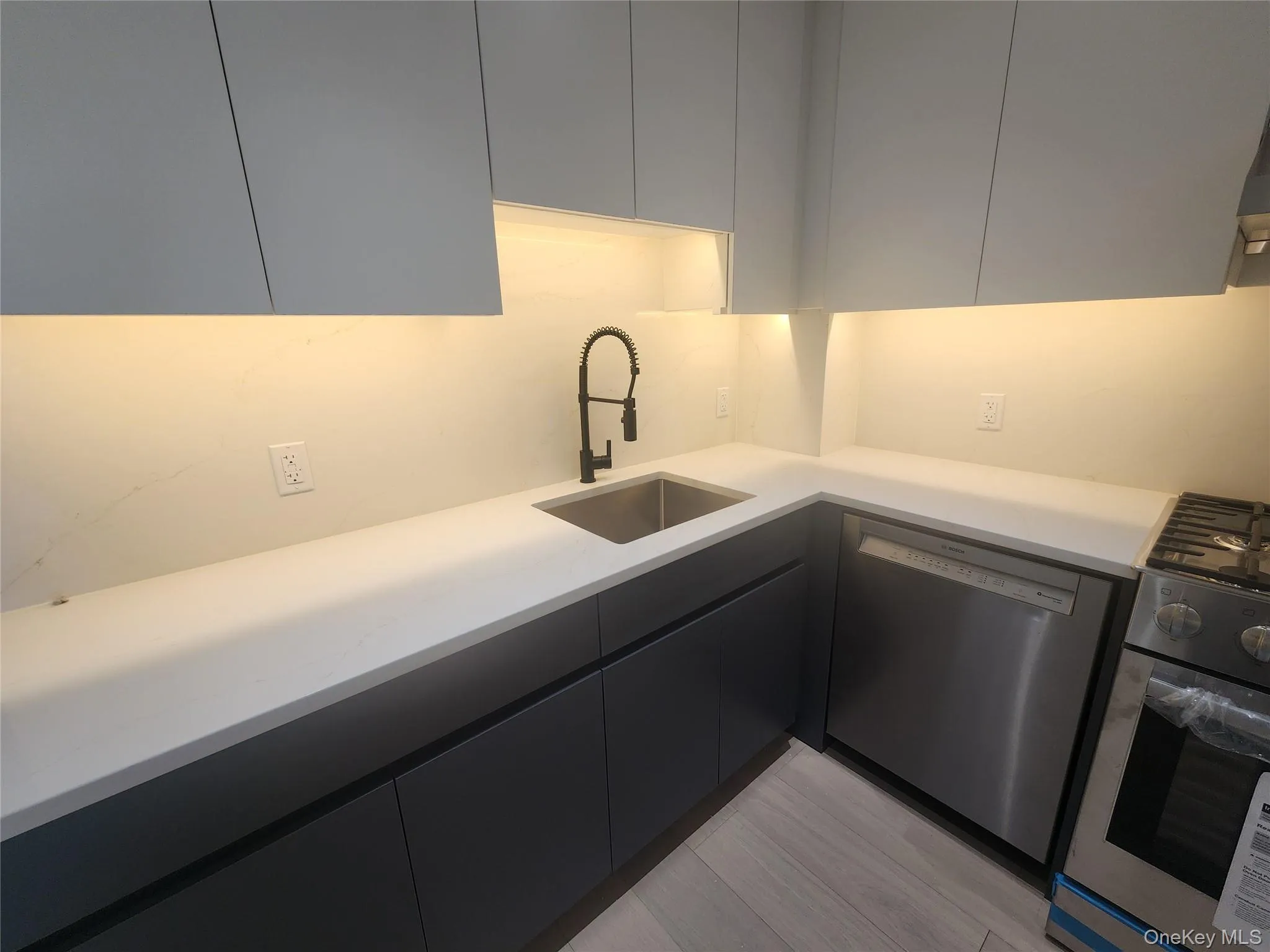 Modern kitchen featuring light gray upper cabinetry and dark gray lower cabinetry Modern kitchen featuring light gray upper cabinetry and dark gray lower cabinetry