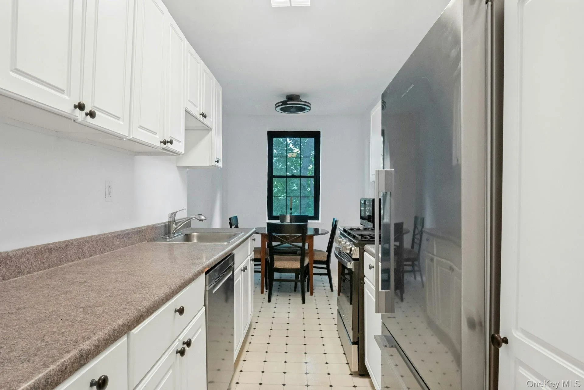 Windowed Kitchen with Stainless Steel Appliances. View toward Dining Area and Treed Views of Golf Course Windowed Kitchen with Stainless Steel Appliances. View toward Dining Area and Treed Views of Golf Course