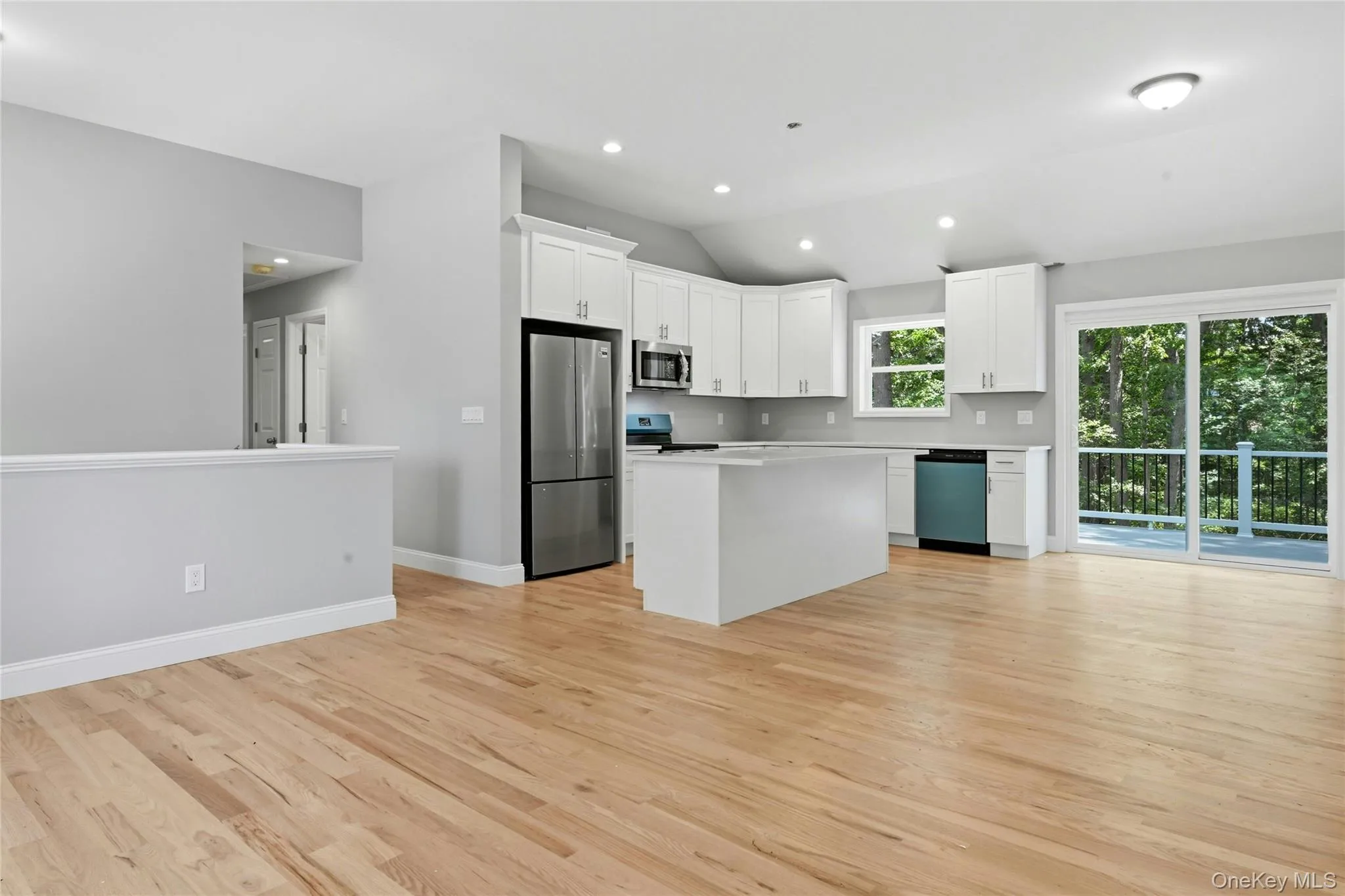 The spacious kitchen features a large center island, quartz countertops, white soft-close cabinets, and a complete stainless steel appliance package . Sliding doors lead to second-story Trex deck, perfect for barbecues and outdoor entertaining. The spacious kitchen features a large center island, quartz countertops, white soft-close cabinets, and a complete stainless steel appliance package . Sliding doors lead to second-story Trex deck, perfect for barbecues and outdoor entertaining.
