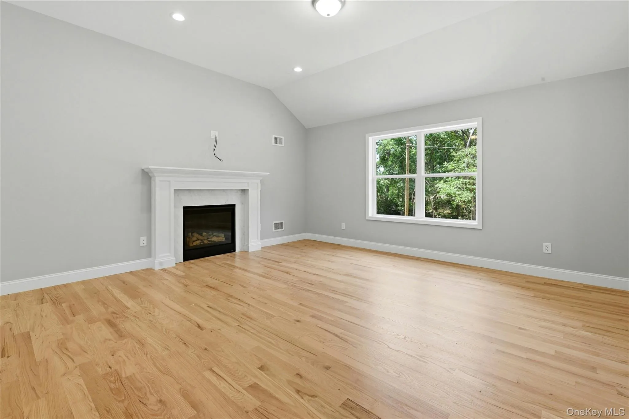 The spacious living area features soaring vaulted ceiling, recessed lighting, and a cozy gas fireplace , creating a warm and inviting atmosphere. The spacious living area features soaring vaulted ceiling, recessed lighting, and a cozy gas fireplace , creating a warm and inviting atmosphere.