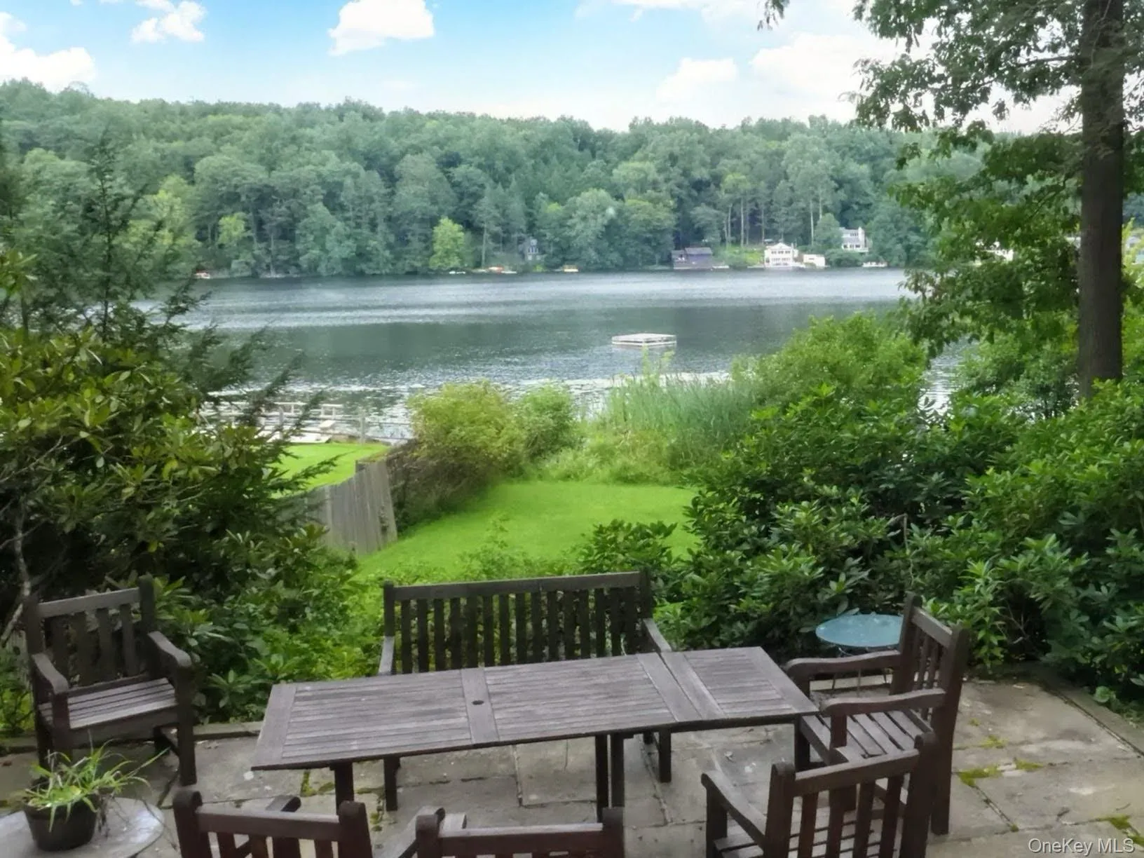The backyard patio overlooks a small lawn, dock and swim area in the lake. The backyard patio overlooks a small lawn, dock and swim area in the lake.