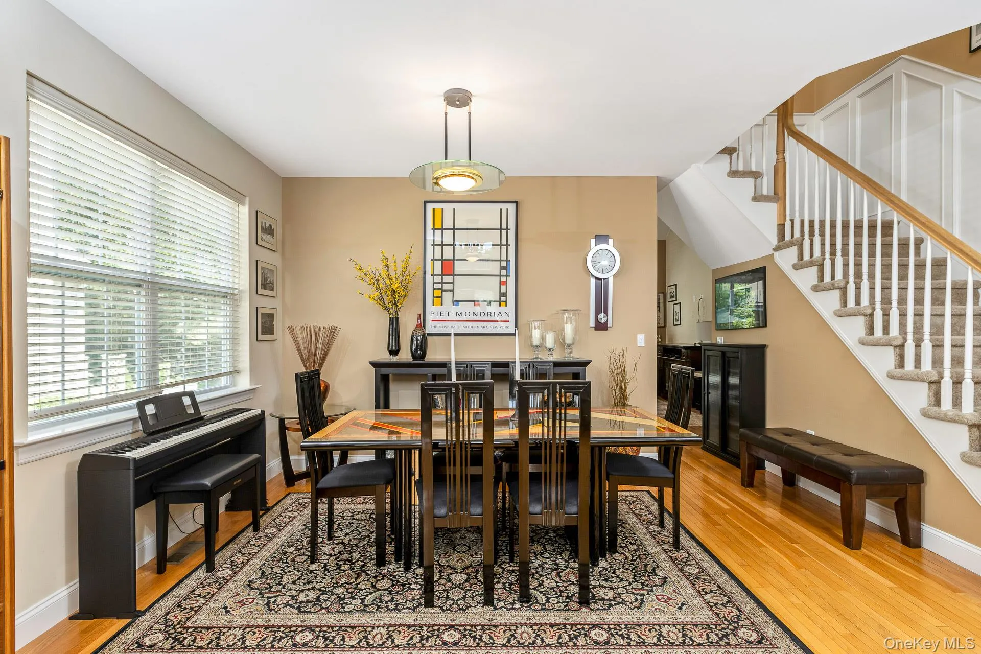 Dining area with a contemporary chandelier, large window with blinds Dining area with a contemporary chandelier, large window with blinds