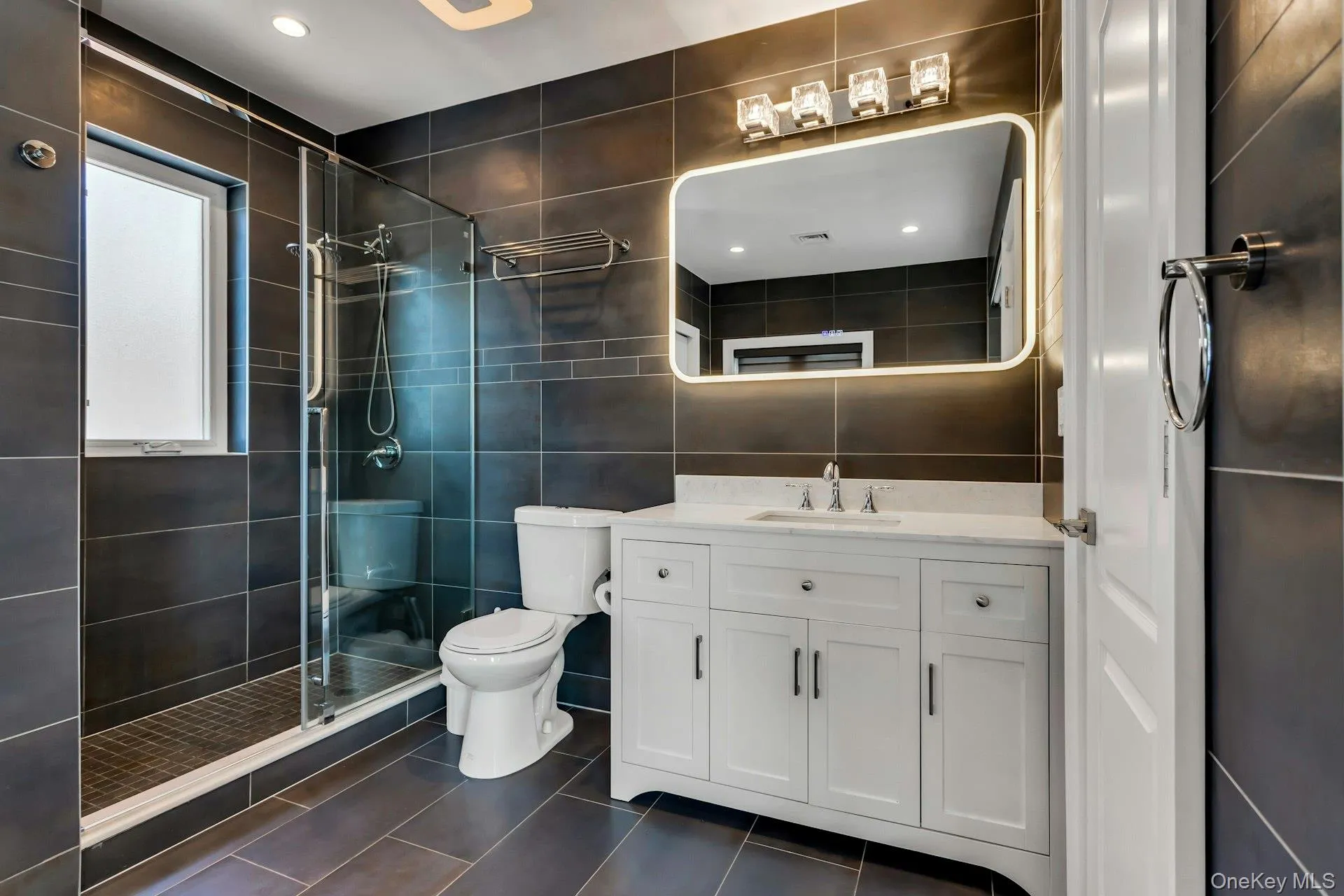 Contemporary bathroom featuring slate-toned tiled walls and flooring Contemporary bathroom featuring slate-toned tiled walls and flooring