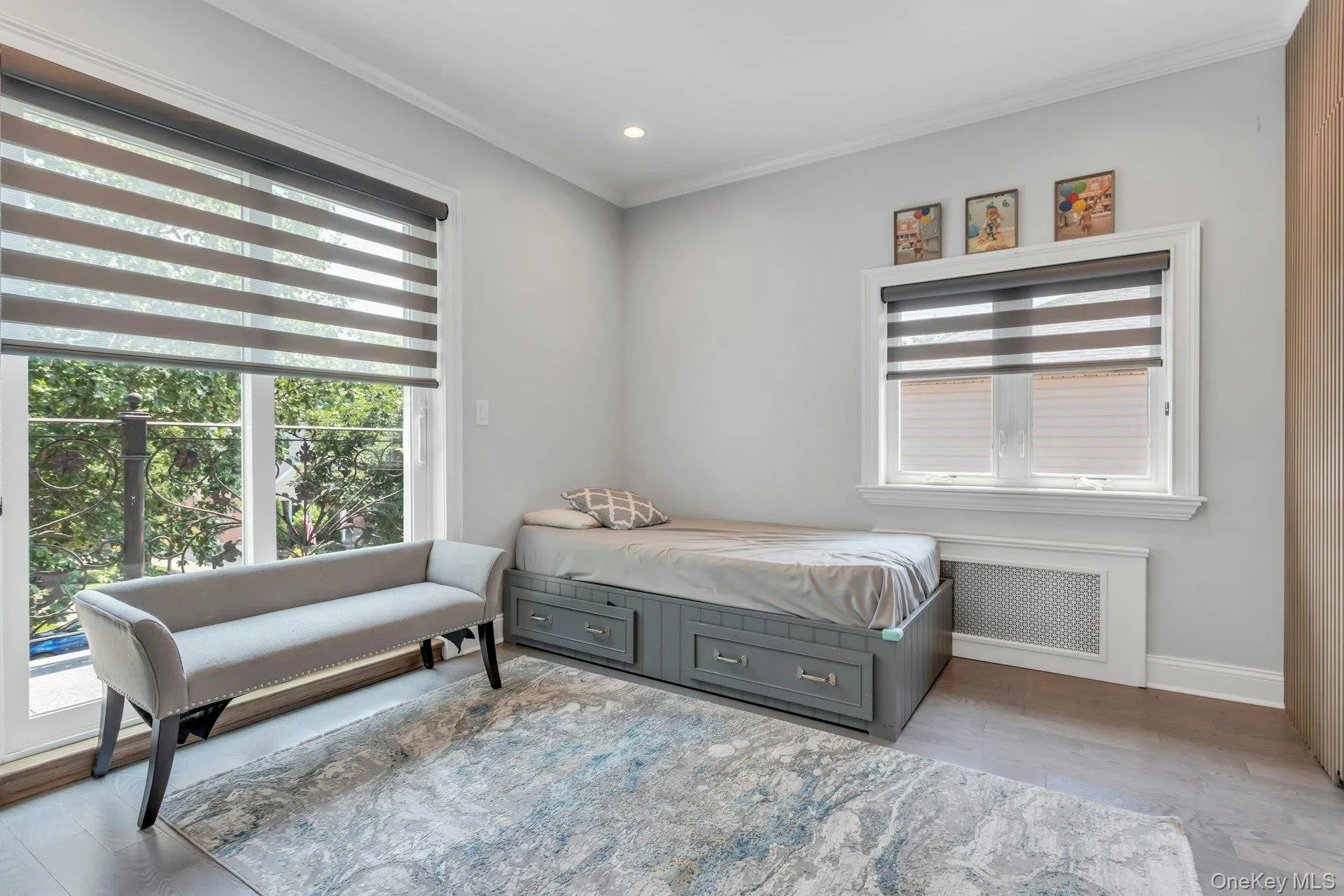 Room featuring wood-finish flooring, light grey walls, and white crown molding. Room featuring wood-finish flooring, light grey walls, and white crown molding.