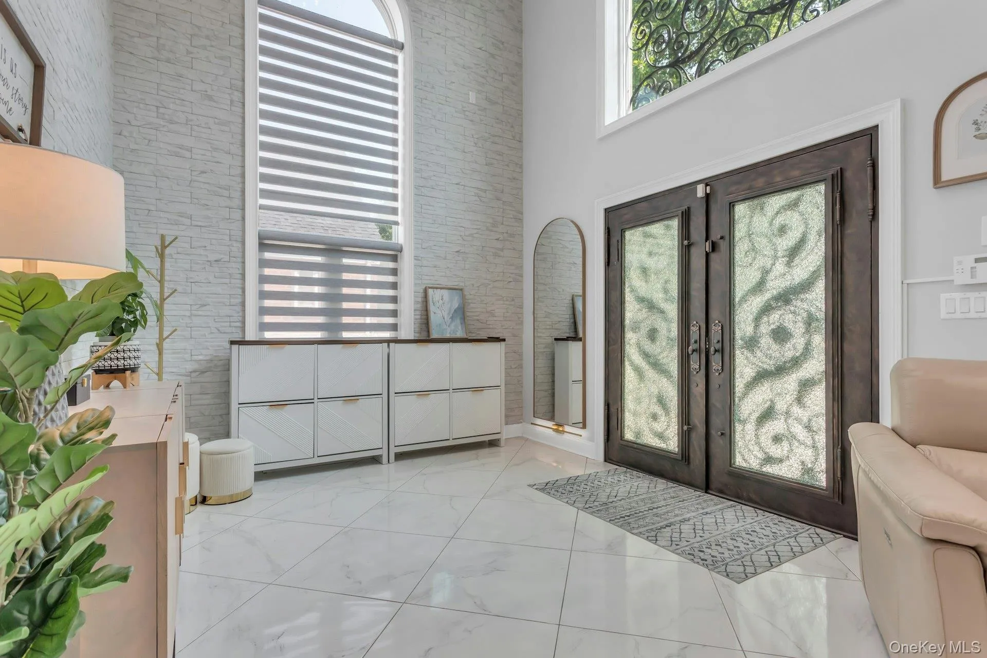 Double iron entry doors featuring crushed glass panels, stacked stone accent wall, over-sized elliptical windows providing a warm ambiance of light, even on the cloudiest of days Double iron entry doors featuring crushed glass panels, stacked stone accent wall, over-sized elliptical windows providing a warm ambiance of light, even on the cloudiest of days