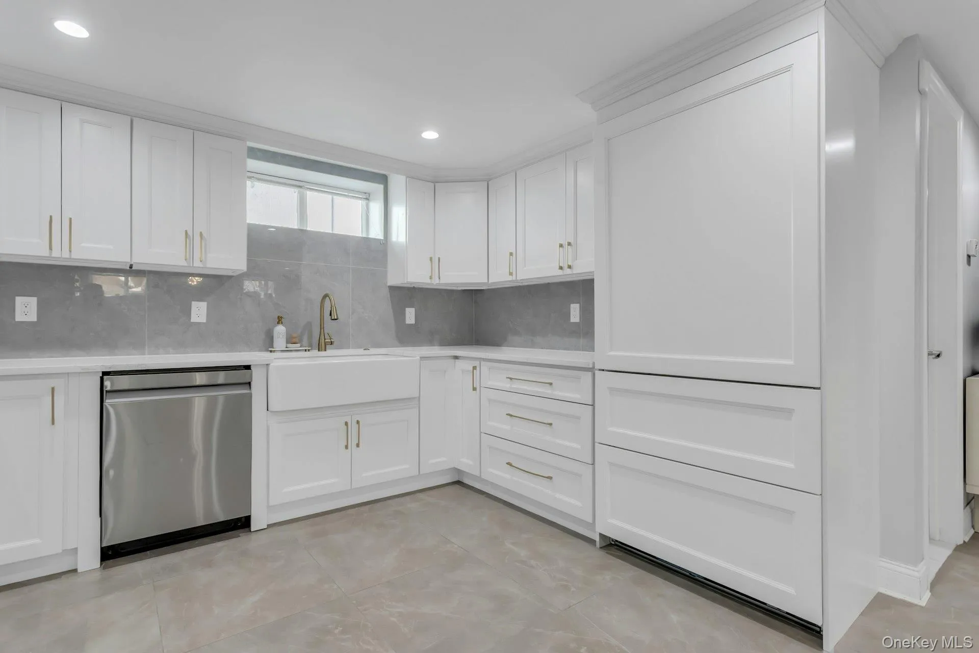 Bonus: Modern kitchen featuring white shaker cabinetry, an integrated white farmhouse sink with a gold-tone faucet, and a stainless steel dishwasher Bonus: Modern kitchen featuring white shaker cabinetry, an integrated white farmhouse sink with a gold-tone faucet, and a stainless steel dishwasher