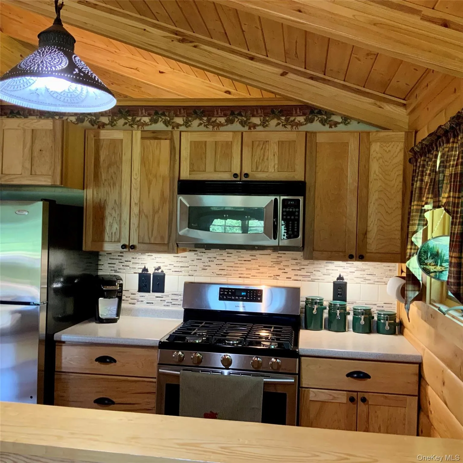 Bright kitchen with stainless steel appliances and rustic wood finishes throughout. Bright kitchen with stainless steel appliances and rustic wood finishes throughout.