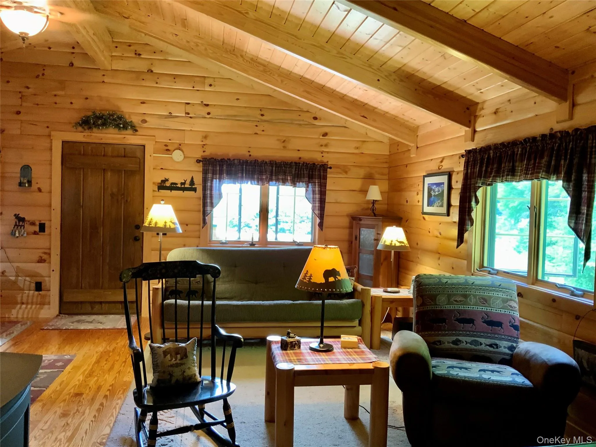 Vaulted ceiling living room featuring warm wood interiors, abundant natural light, and an open layout. Vaulted ceiling living room featuring warm wood interiors, abundant natural light, and an open layout.