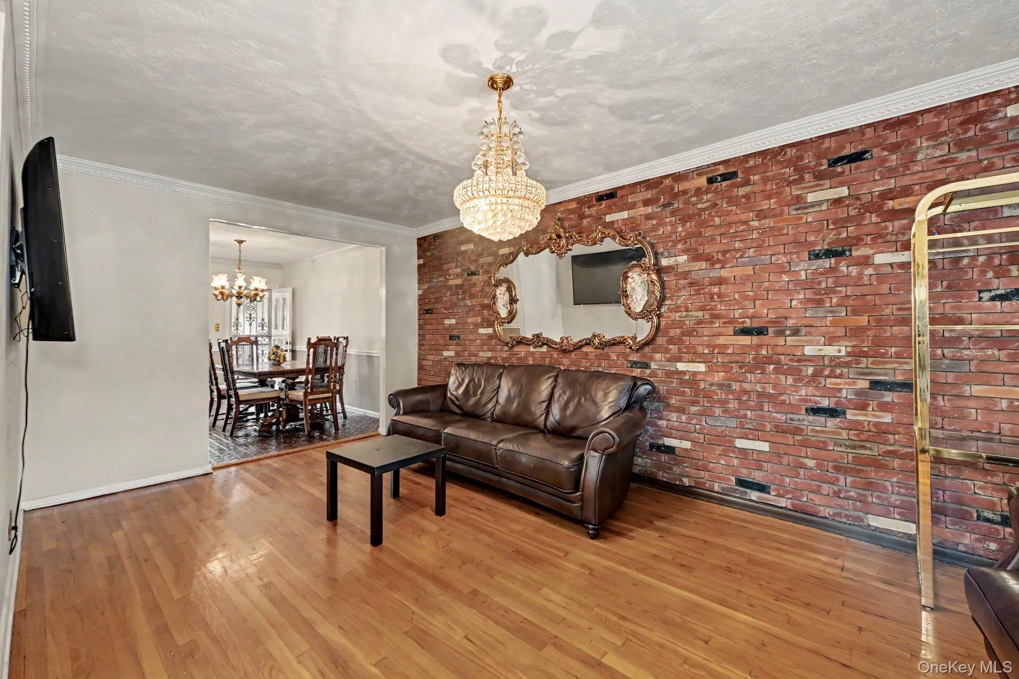 Living room with brick accent wall with view into dining room. Living room with brick accent wall with view into dining room.