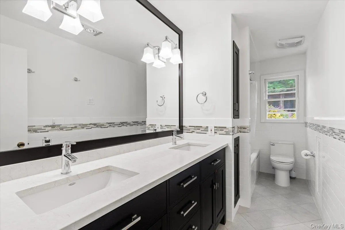 Large hall bath to service two bedrooms on main living level features dual vanity. Large hall bath to service two bedrooms on main living level features dual vanity.