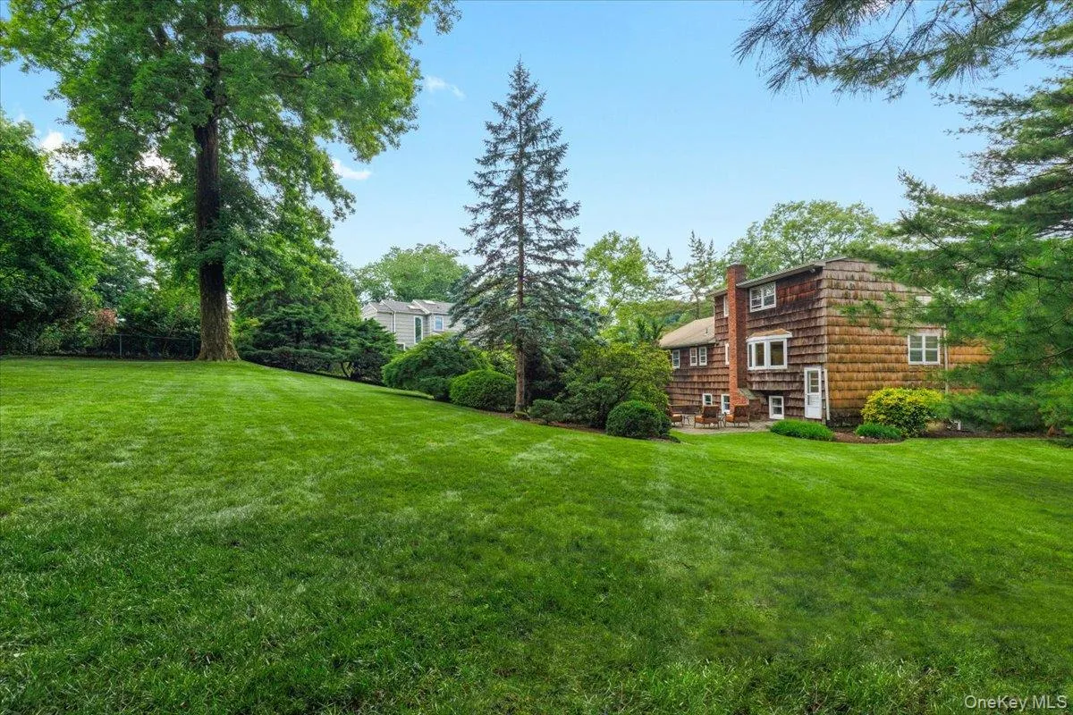 Expansive sloped lawn with mature trees and established landscaping Expansive sloped lawn with mature trees and established landscaping
