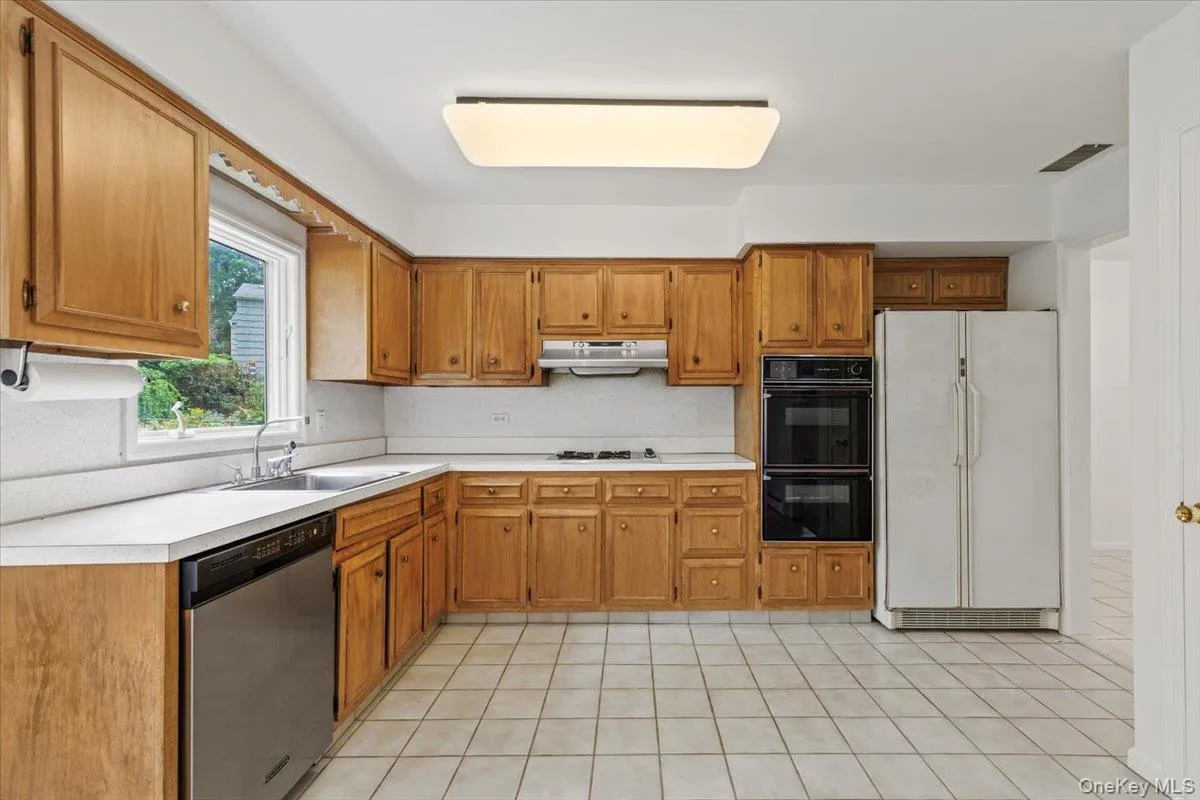 Open generous kitchen features ample cabinet storage, double ovens, dishwasher, and fridge. Open generous kitchen features ample cabinet storage, double ovens, dishwasher, and fridge.