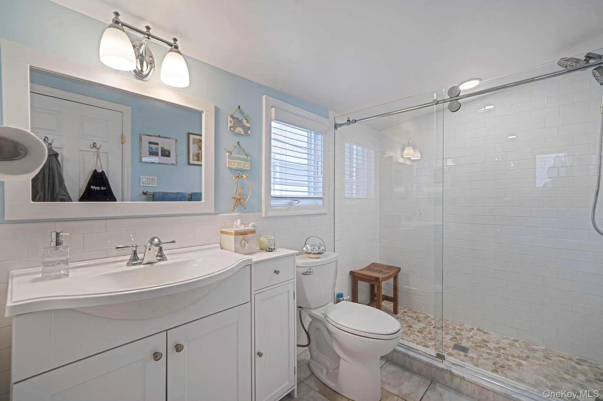 Updated full bath with modern vanity, shower, and stackable washer-dryer. Located on the second level Updated full bath with modern vanity, shower, and stackable washer-dryer. Located on the second level