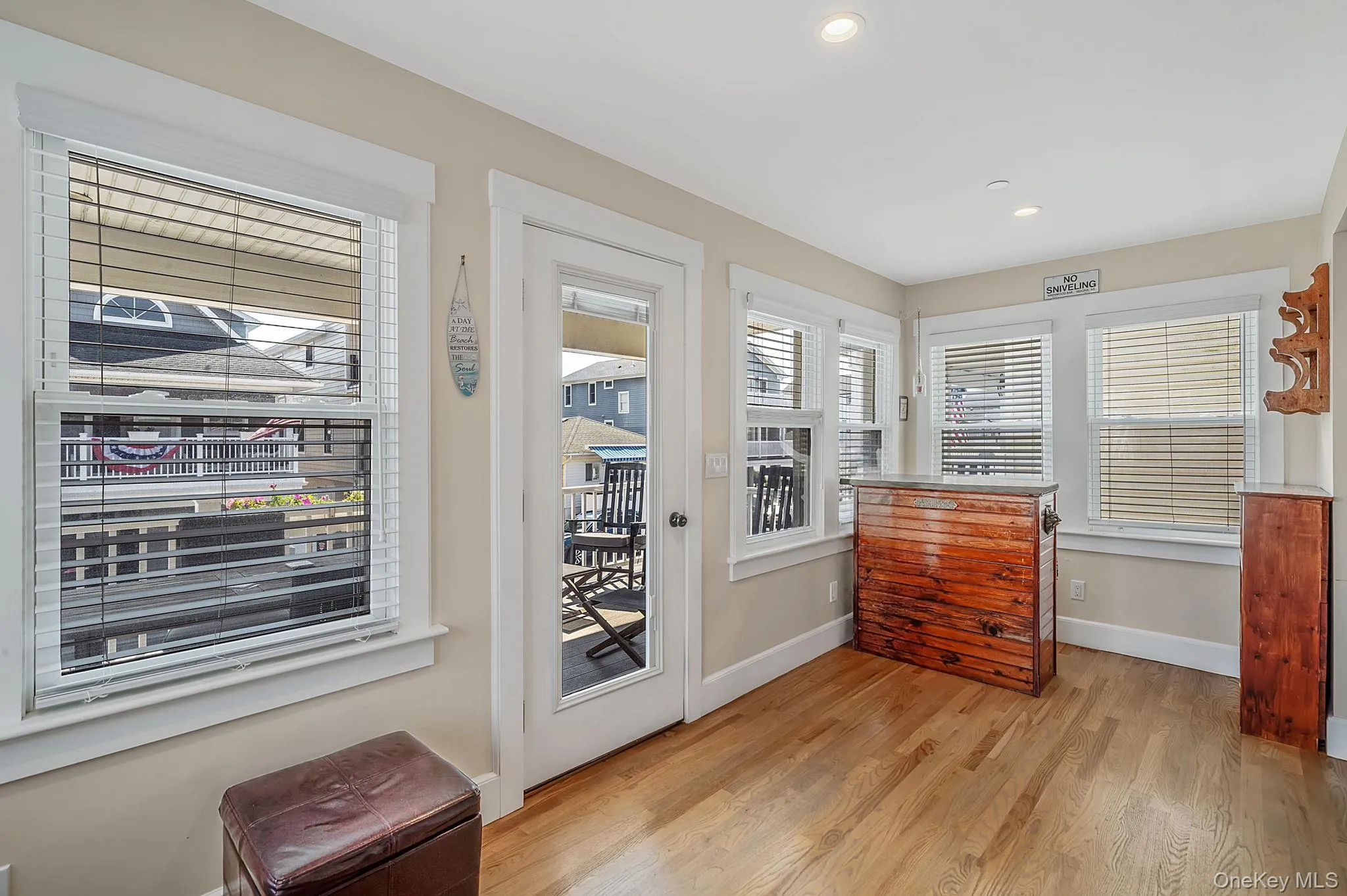 Bright, sun-filled living room with hardwood floors and access to second level covered deck Bright, sun-filled living room with hardwood floors and access to second level covered deck