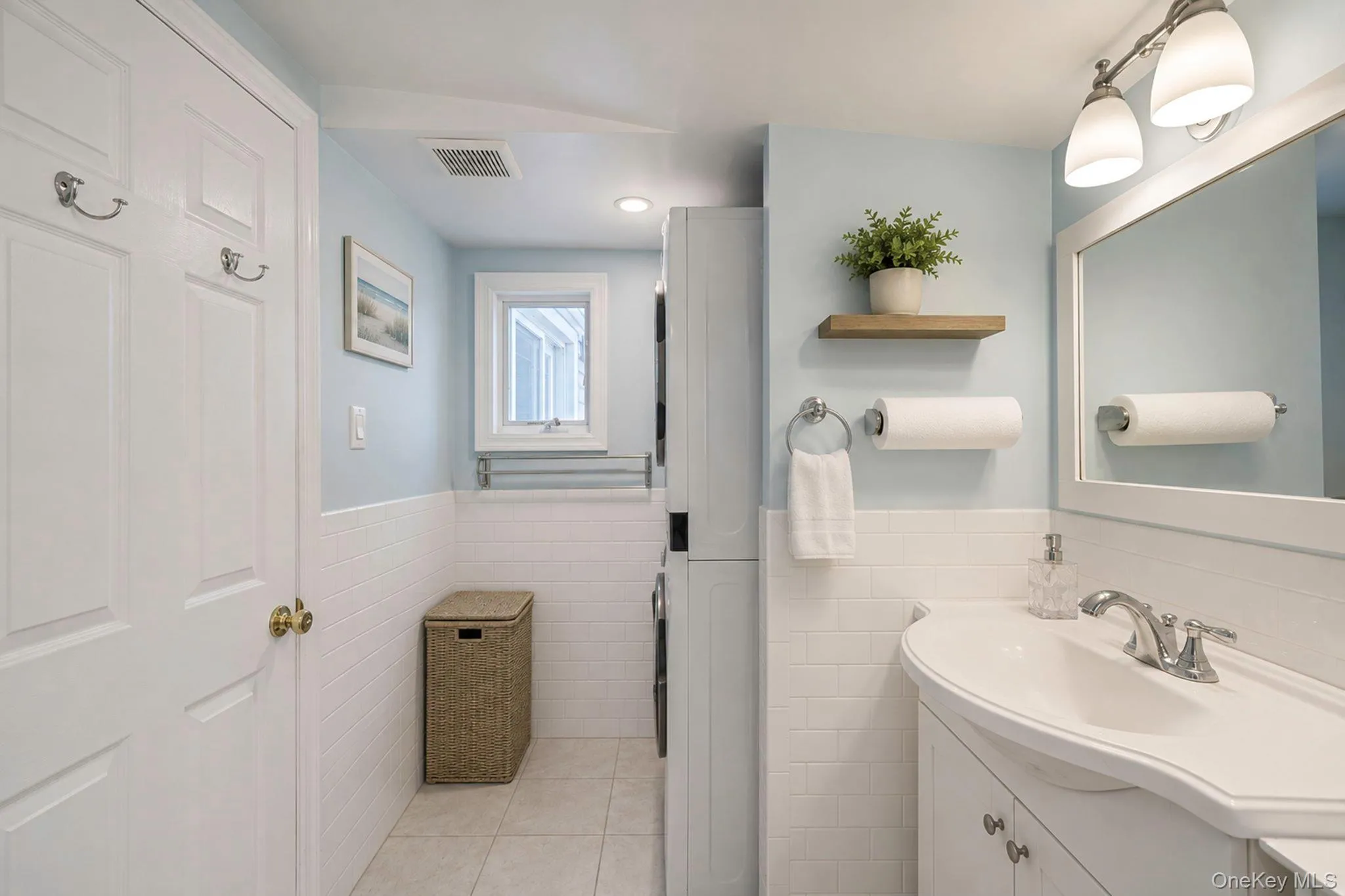 Updated full bath with modern vanity, shower, and stackable washer-dryer. Located on the second level Updated full bath with modern vanity, shower, and stackable washer-dryer. Located on the second level