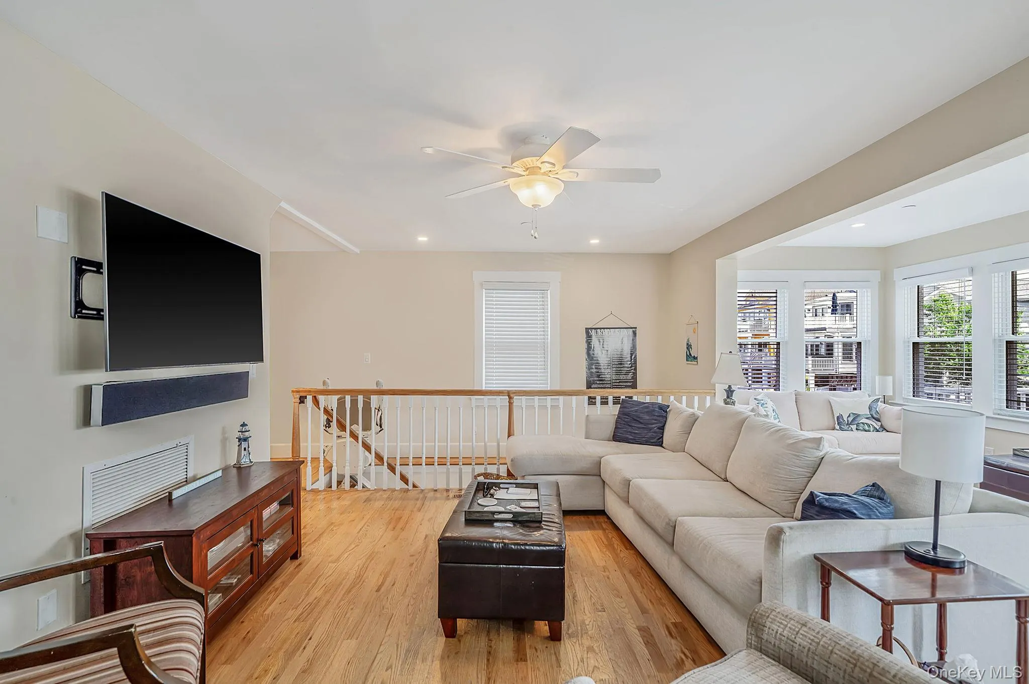 Open-concept living space with wood-finish flooring, recessed lighting, and a ceiling fan Open-concept living space with wood-finish flooring, recessed lighting, and a ceiling fan