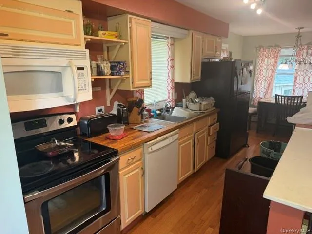 Kitchen featuring wood-finish flooring, stainless steel range, and wood countertops Kitchen featuring wood-finish flooring, stainless steel range, and wood countertops