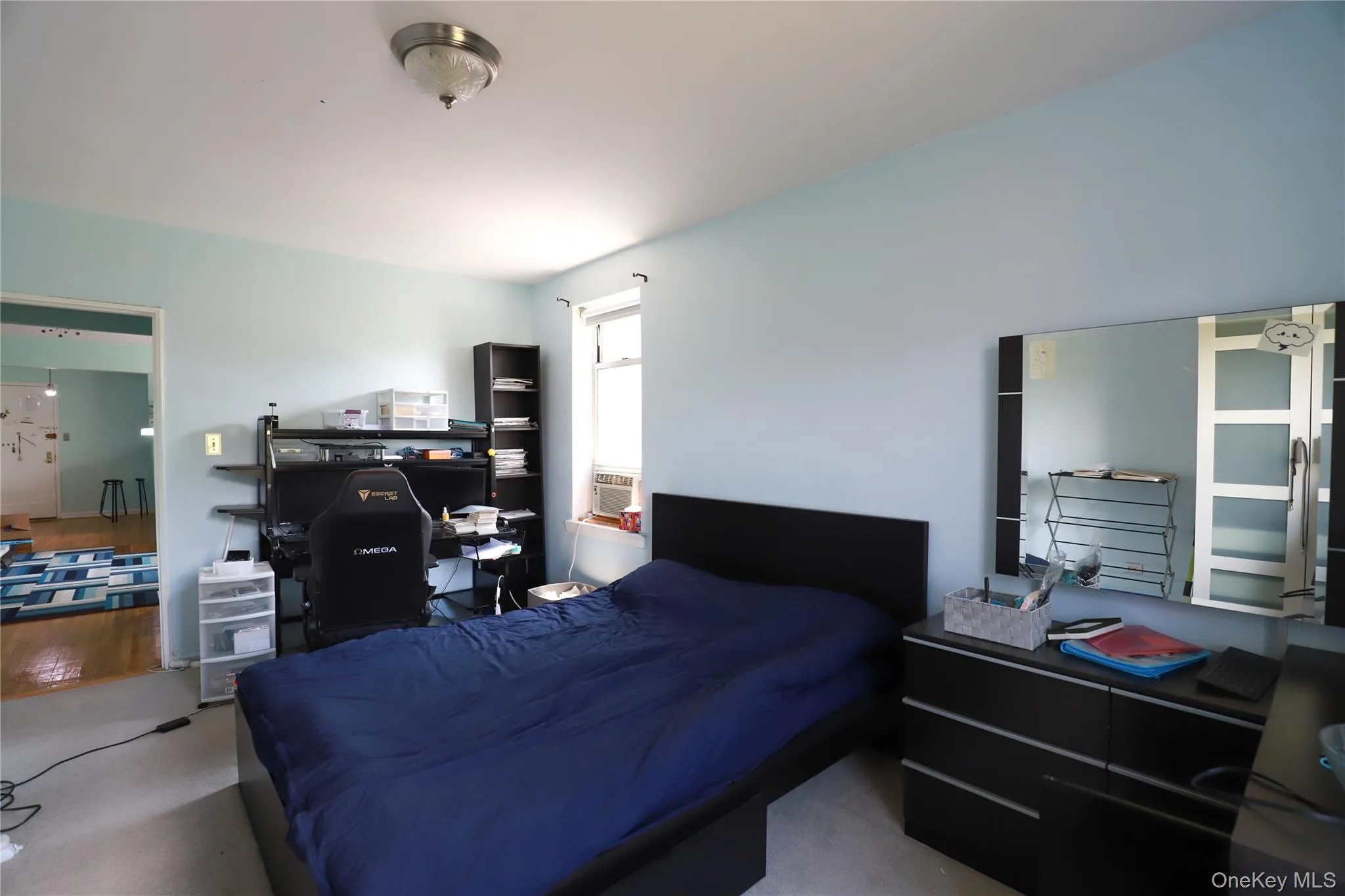 Bedroom featuring light blue walls and neutral carpeting Bedroom featuring light blue walls and neutral carpeting
