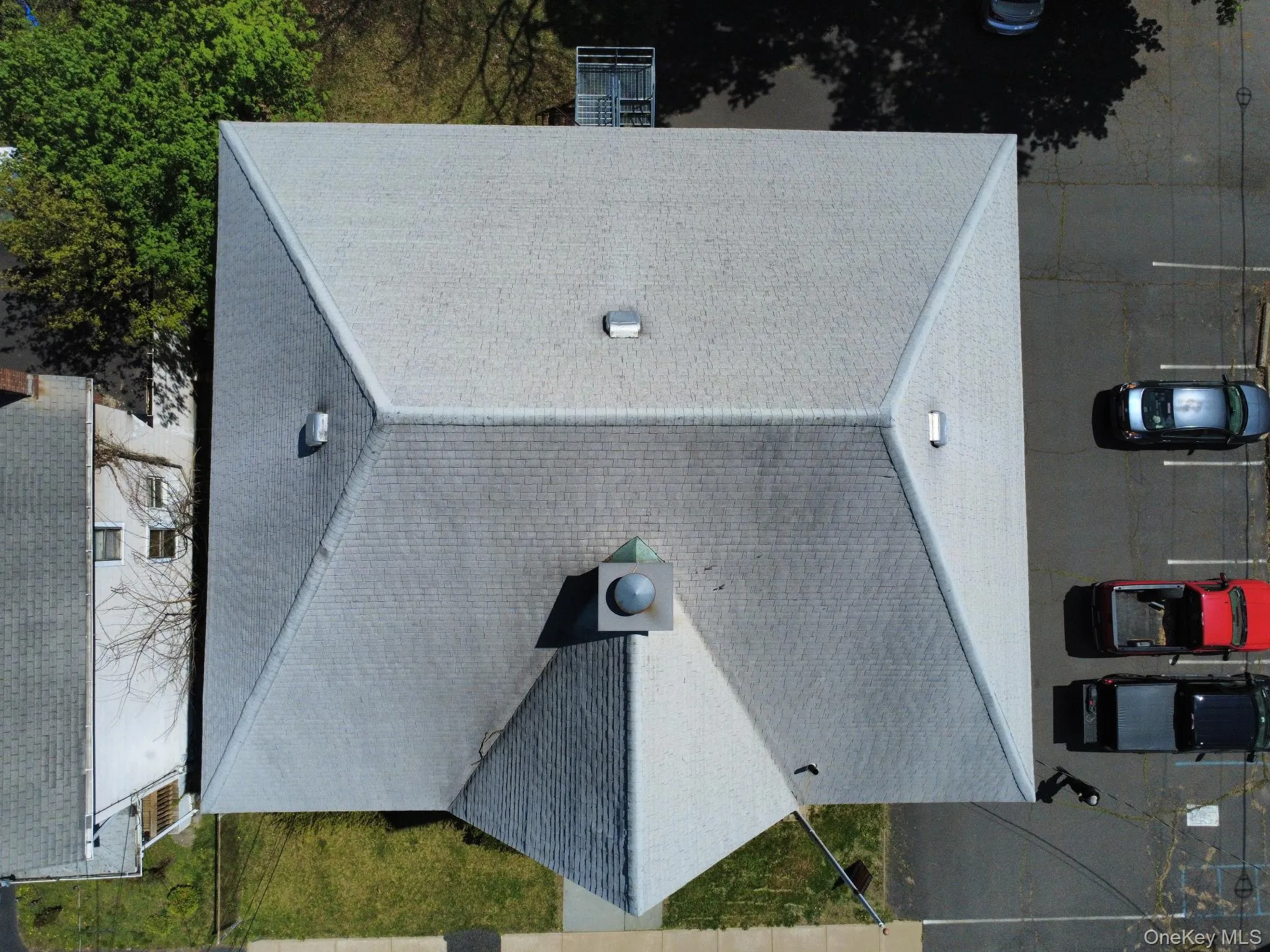 Gable roof featuring light gray architectural shingles, multiple roof vents, and a central square vent Gable roof featuring light gray architectural shingles, multiple roof vents, and a central square vent
