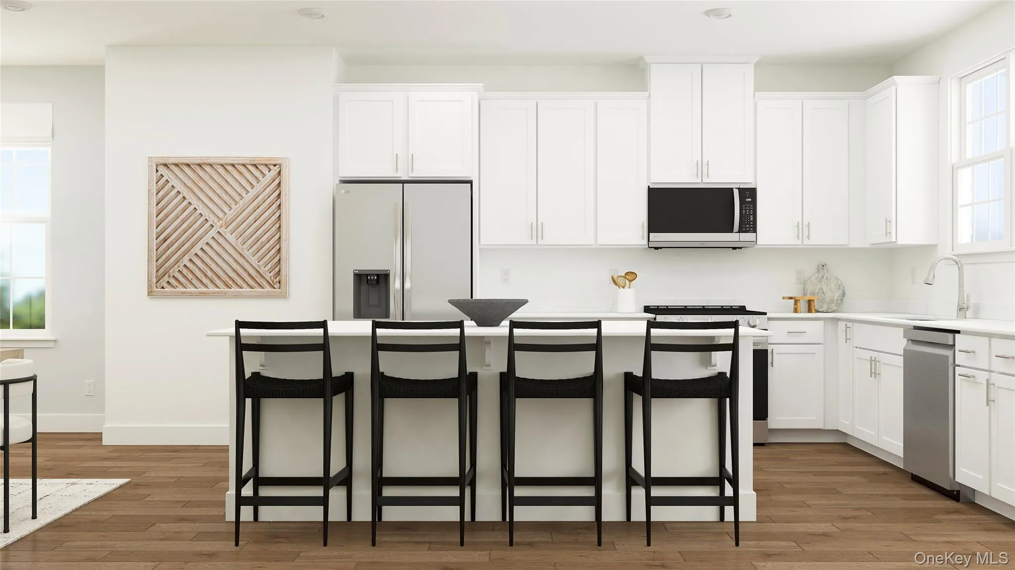 Kitchen featuring a kitchen breakfast bar, light countertops, stainless steel appliances, a center island, and white cabinetry Kitchen featuring a kitchen breakfast bar, light countertops, stainless steel appliances, a center island, and white cabinetry