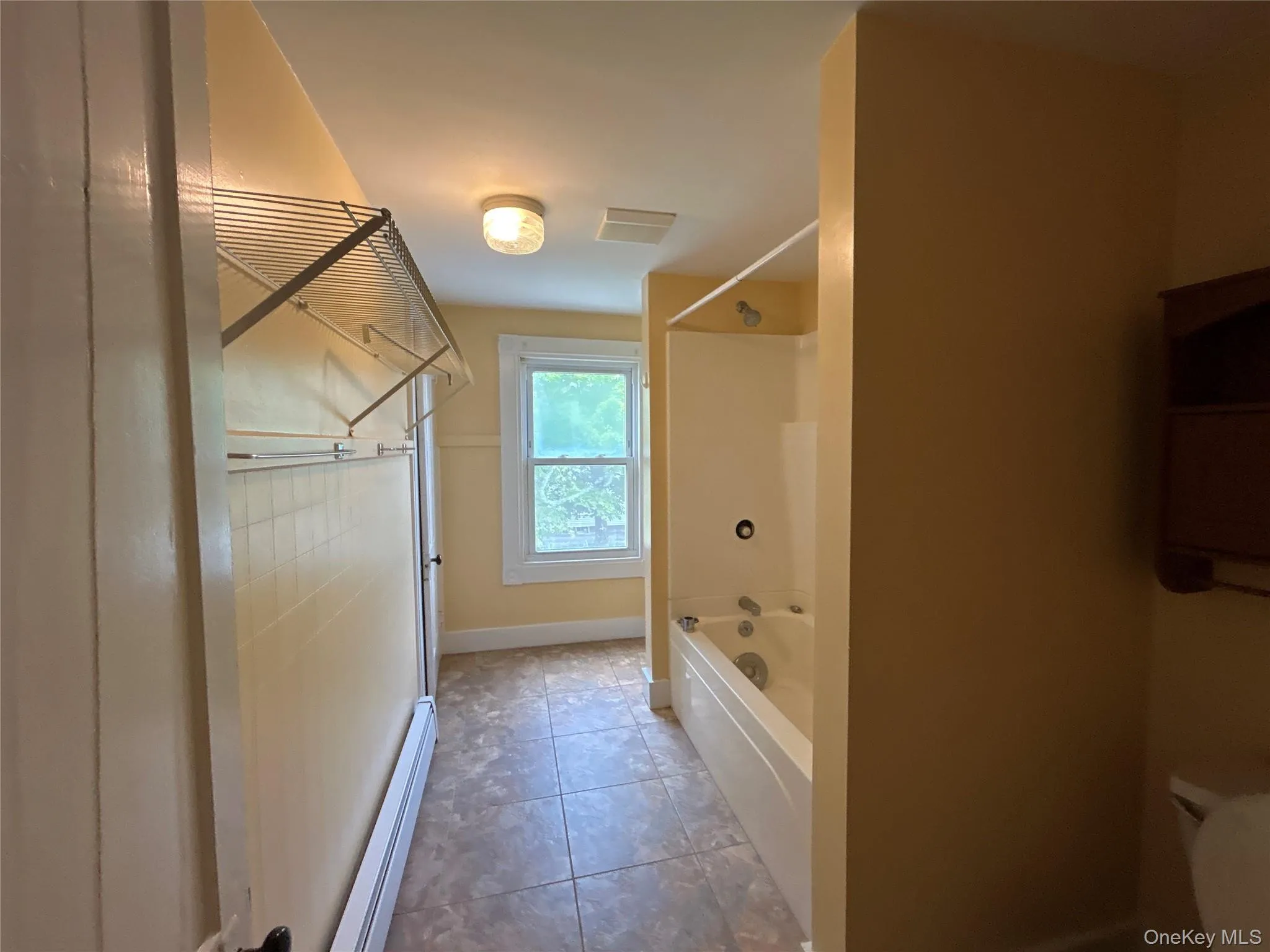 Full bath with tile floor and a linen closet Full bath with tile floor and a linen closet
