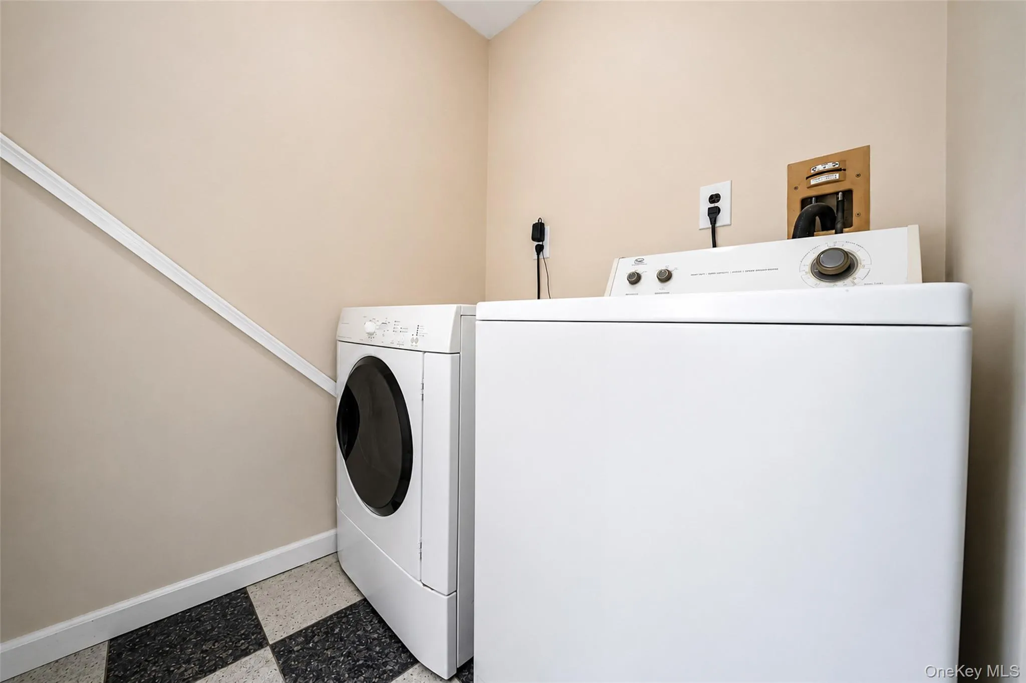 Dedicated laundry area featuring a front-loading washing machine and a top-loading dryer Dedicated laundry area featuring a front-loading washing machine and a top-loading dryer