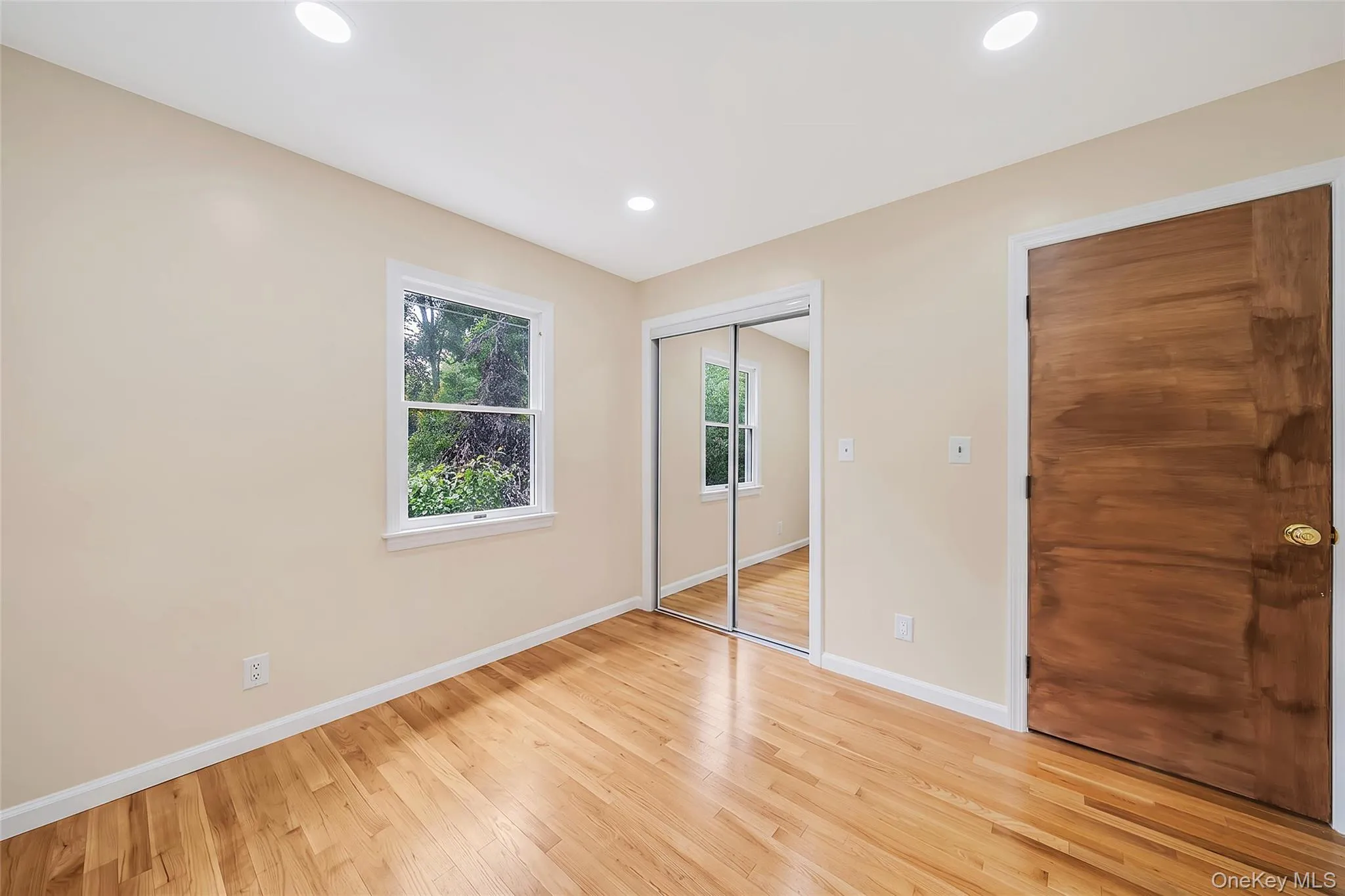 Light wood-finish flooring with white baseboards and neutral wall paint Light wood-finish flooring with white baseboards and neutral wall paint