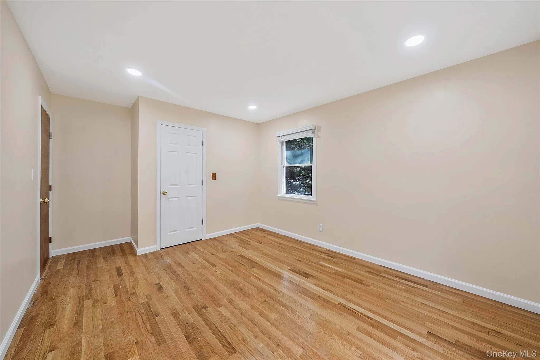 Hardwood flooring extends throughout this room, complemented by light neutral wall paint and recessed ceiling lighting Hardwood flooring extends throughout this room, complemented by light neutral wall paint and recessed ceiling lighting
