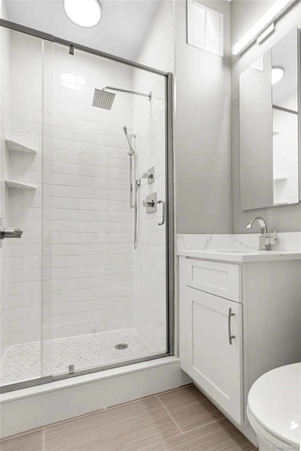 Bathroom with vanity and a shower stall Bathroom with vanity and a shower stall
