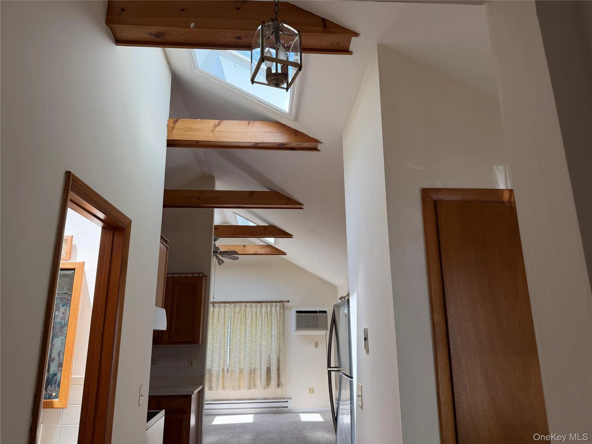 Features beamed ceiling & skylight view from bath area hallway toward LR Features beamed ceiling & skylight view from bath area hallway toward LR