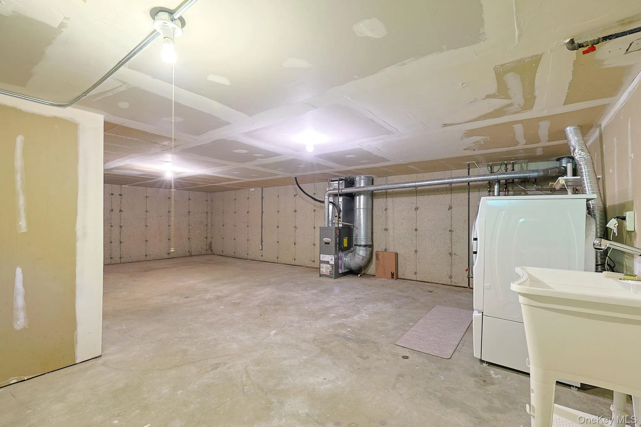 Unfinished lower level featuring concrete flooring and exposed ceiling joists Unfinished lower level featuring concrete flooring and exposed ceiling joists