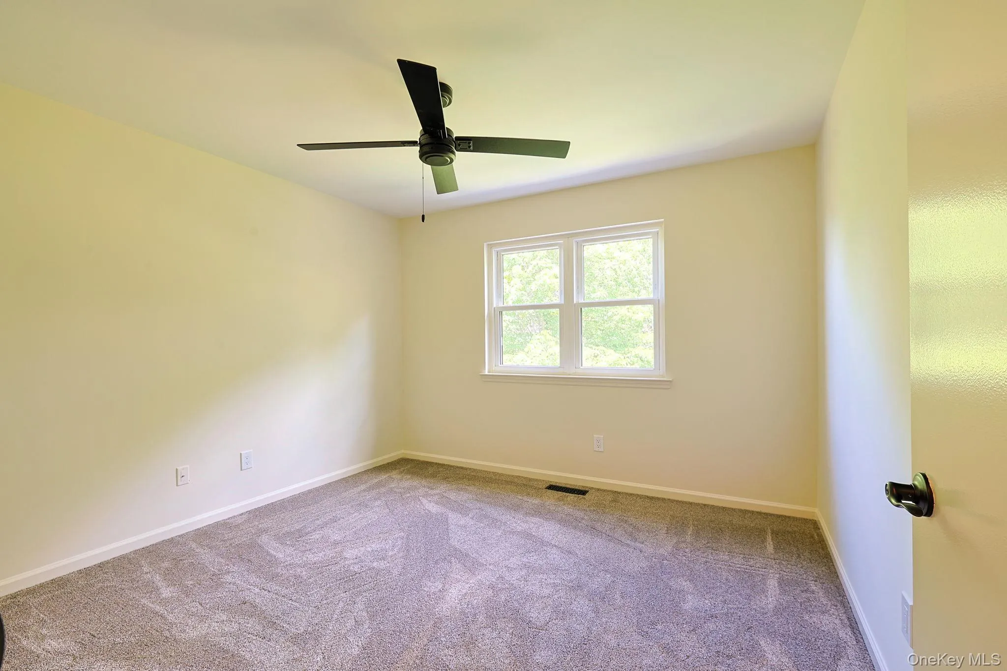 Second bedroom featuring neutral-toned walls and plush gray carpeting Second bedroom featuring neutral-toned walls and plush gray carpeting
