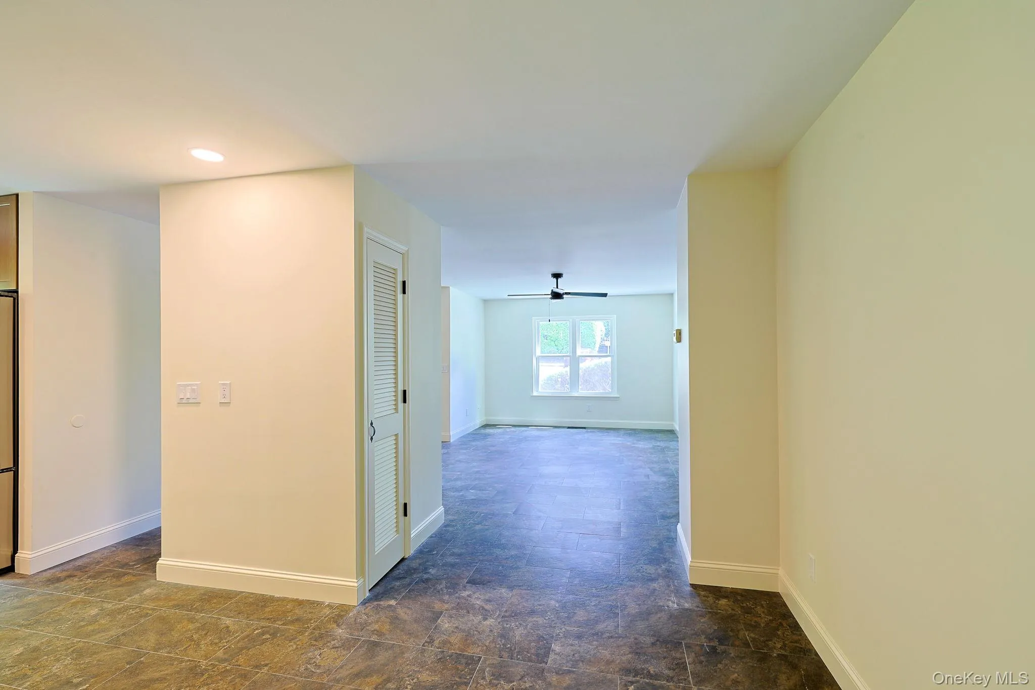 Open-concept interior featuring light-toned walls, tile flooring, and recessed lighting Open-concept interior featuring light-toned walls, tile flooring, and recessed lighting