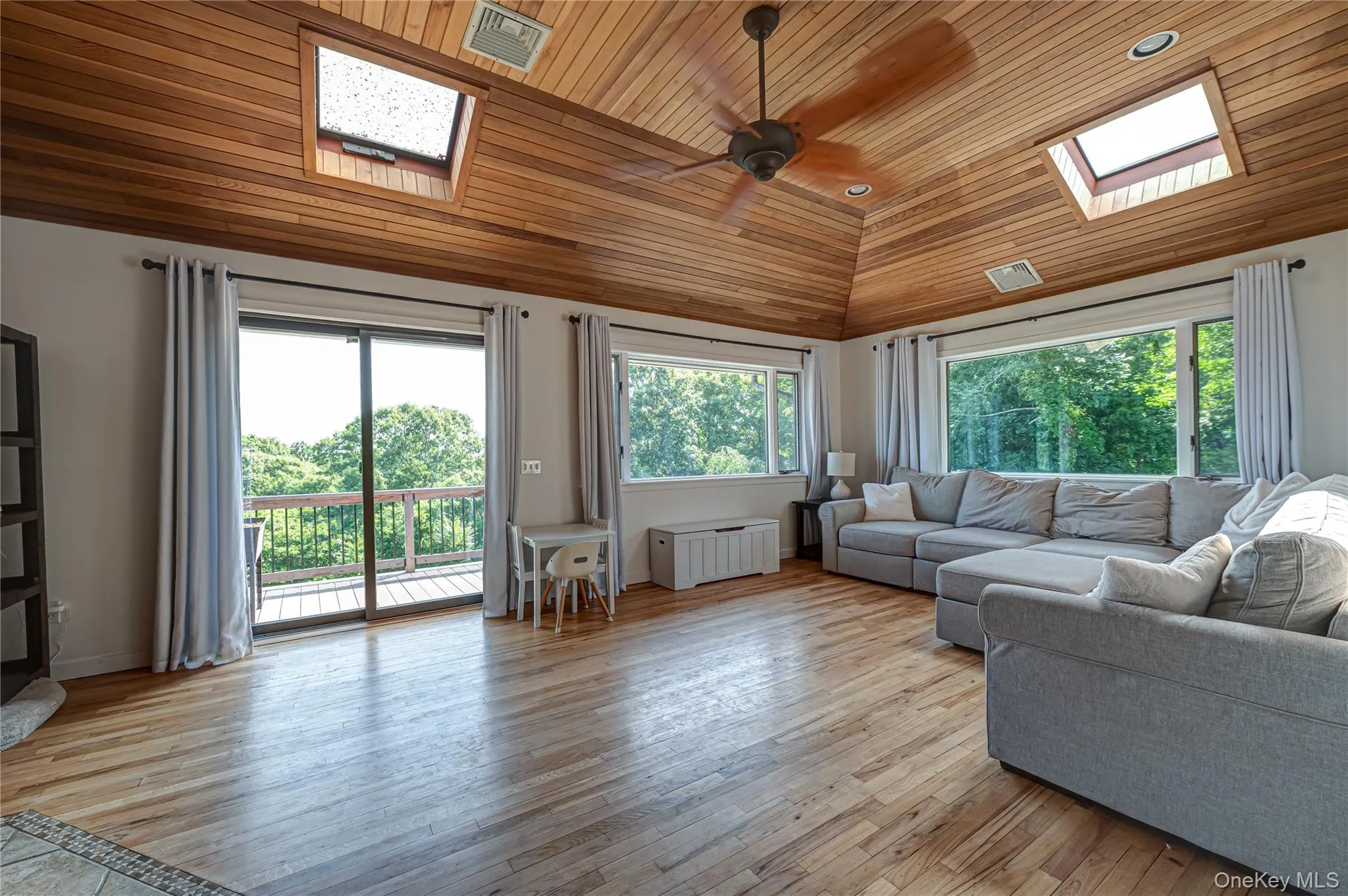Huge Den with sliders to 2nd side deck overlooking natural 1/2 acre. skylights & natural wood flooring Huge Den with sliders to 2nd side deck overlooking natural 1/2 acre. skylights & natural wood flooring