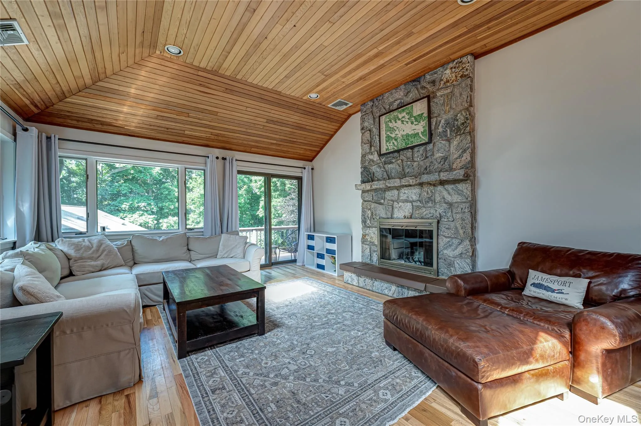 Living room with wood burning stove & sliders to side deck overlooking back yard Living room with wood burning stove & sliders to side deck overlooking back yard
