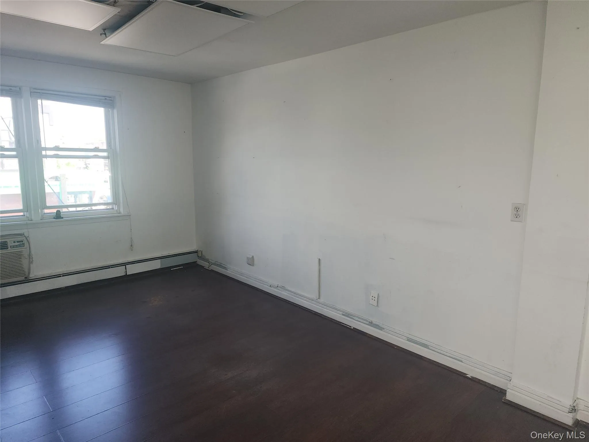 Interior room with dark wood-finish flooring and white walls Interior room with dark wood-finish flooring and white walls