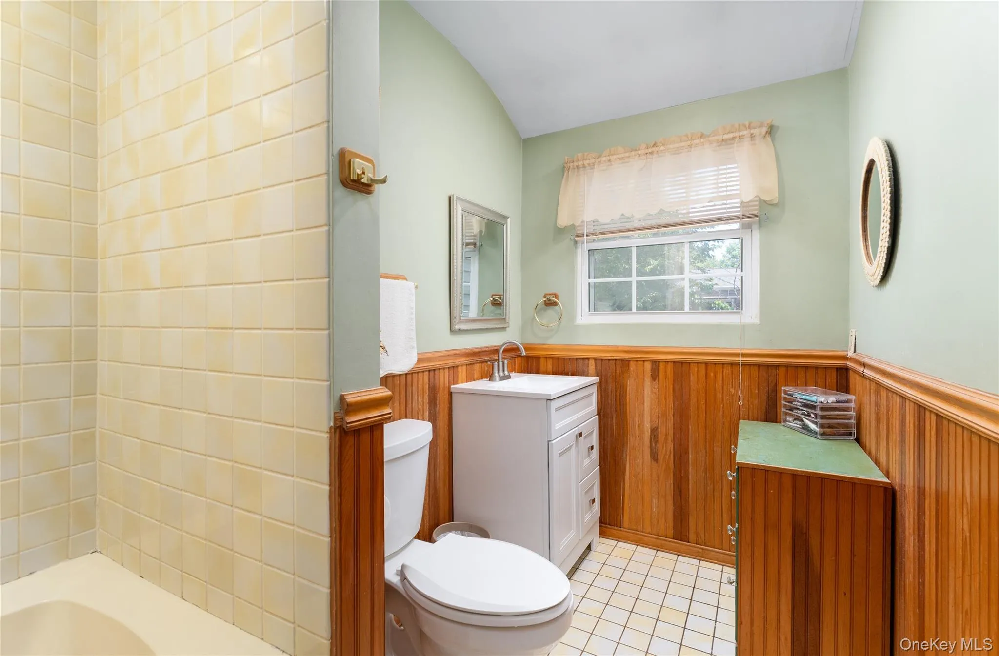 Full hall bathroom, newer vanity and toilet, custom wainscoting, shower/tub Full hall bathroom, newer vanity and toilet, custom wainscoting, shower/tub