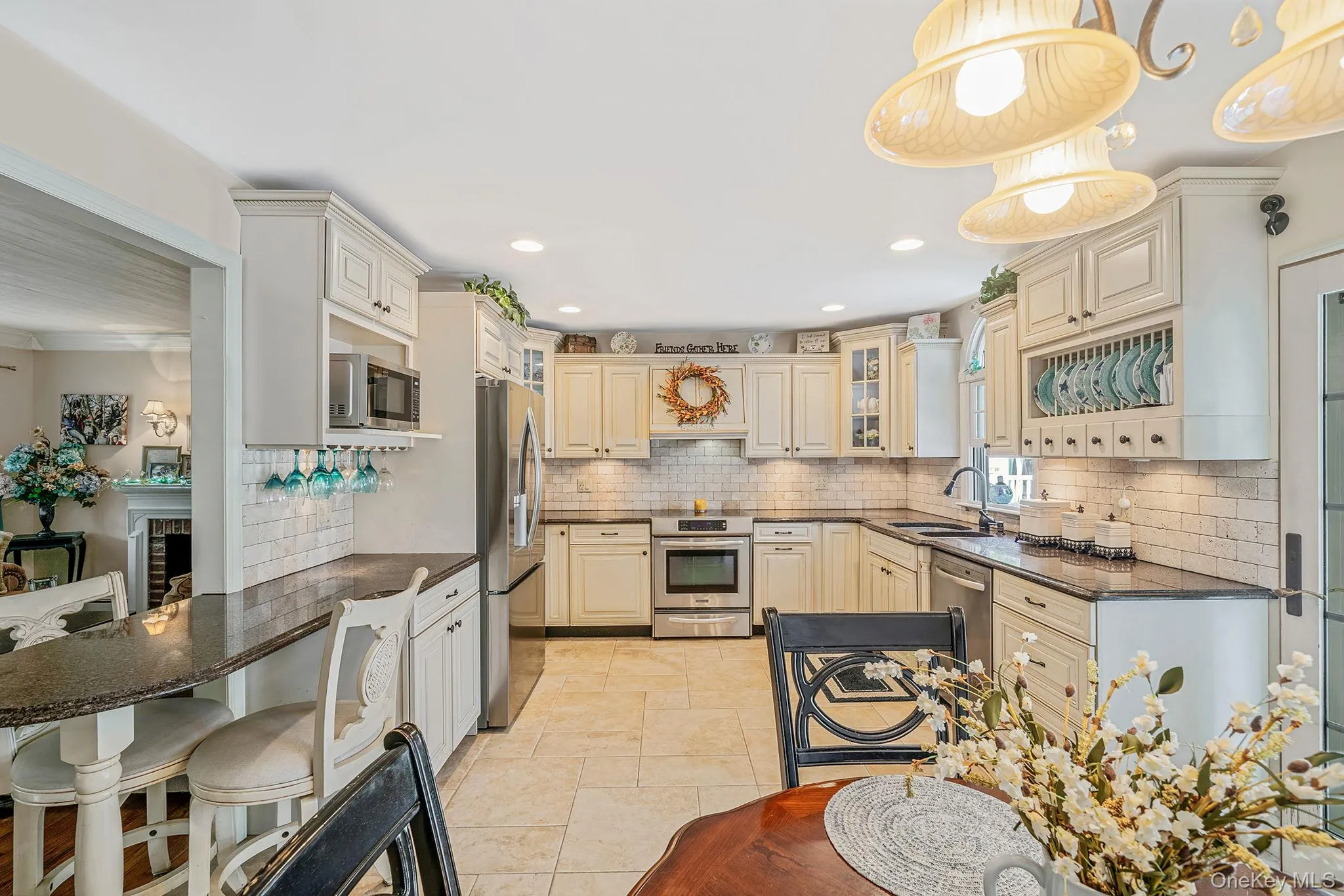 Kitchen featuring extensive cabinetry, dark countertops, a subway tile backsplash, and stainless steel appliances Kitchen featuring extensive cabinetry, dark countertops, a subway tile backsplash, and stainless steel appliances