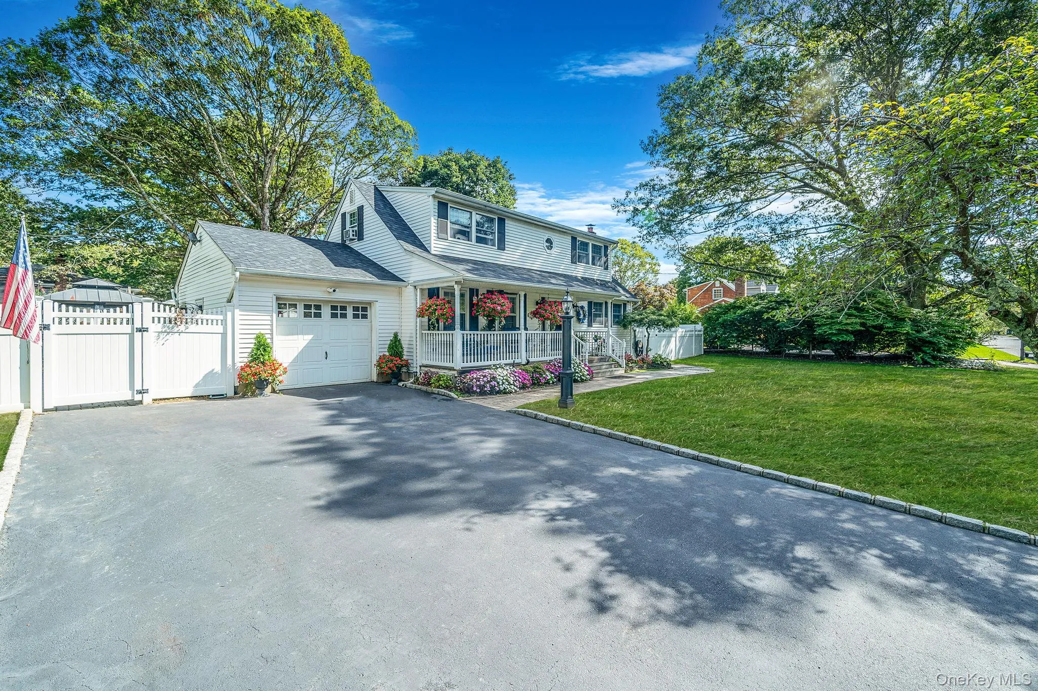 White siding exterior with a dark shingle roof and a covered front porch featuring white railings White siding exterior with a dark shingle roof and a covered front porch featuring white railings