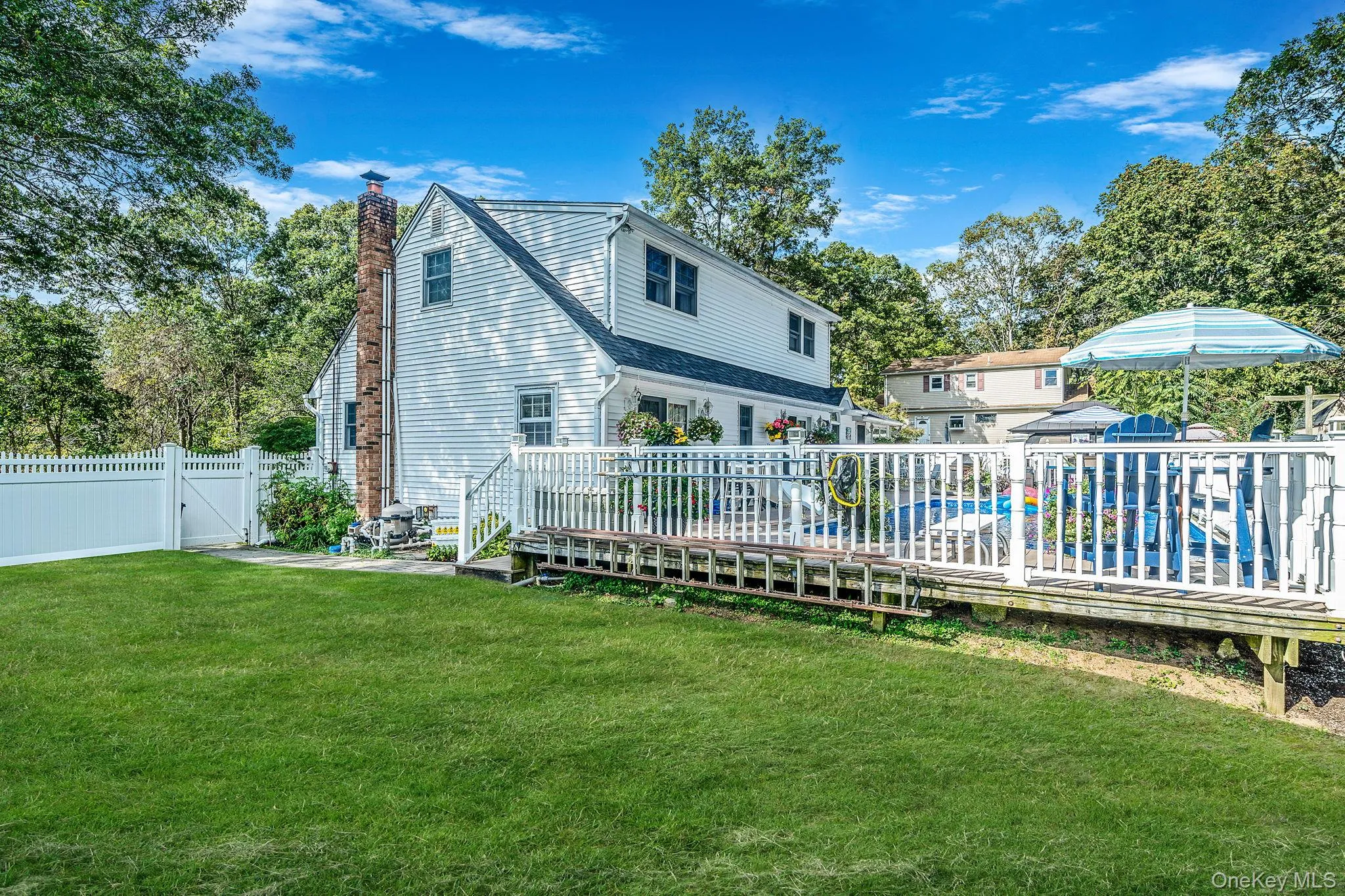 Back yard with deck, pool and white fencing Back yard with deck, pool and white fencing