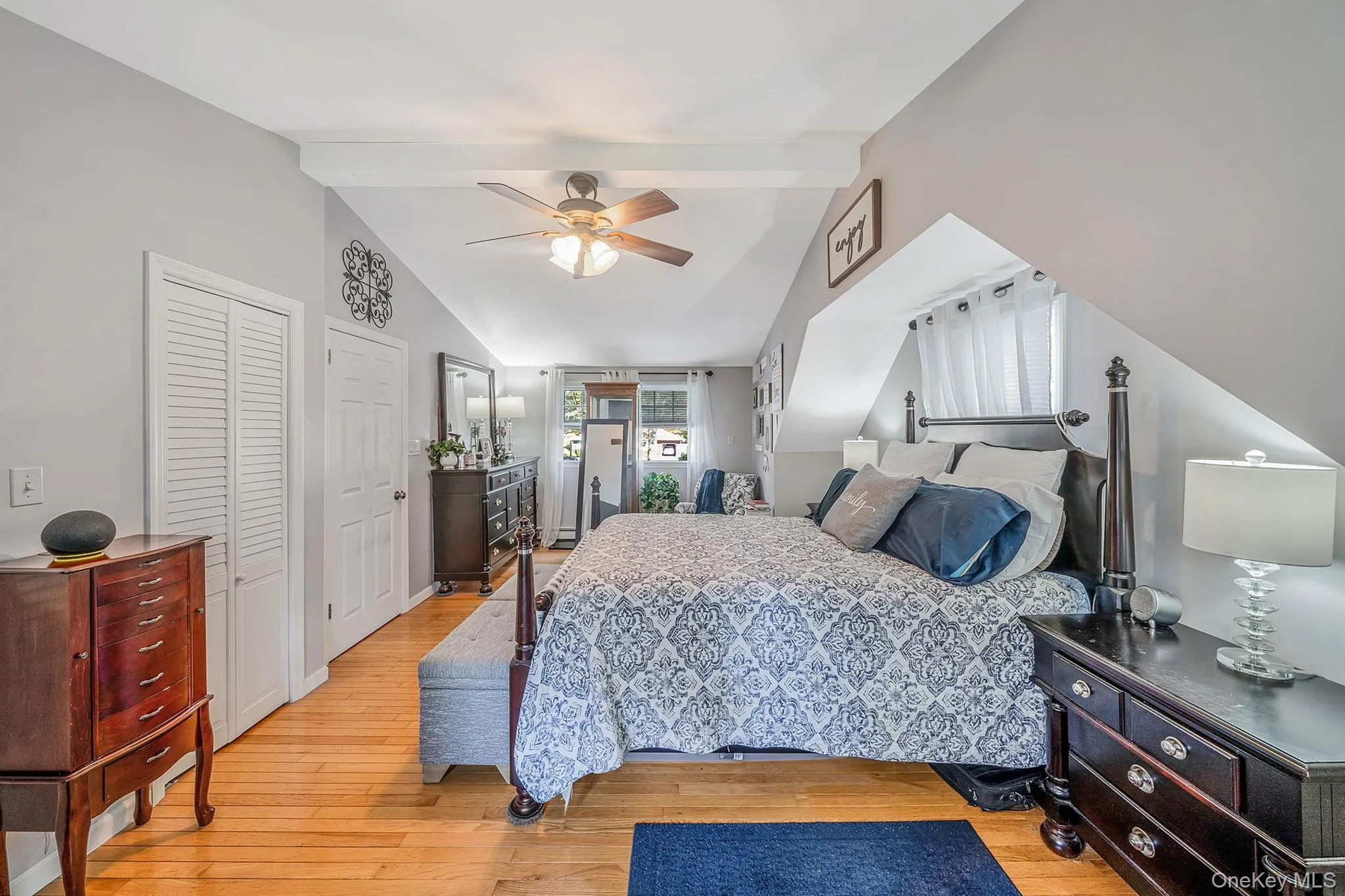 Bedroom featuring wood-finish flooring and a vaulted ceiling with exposed beams Bedroom featuring wood-finish flooring and a vaulted ceiling with exposed beams