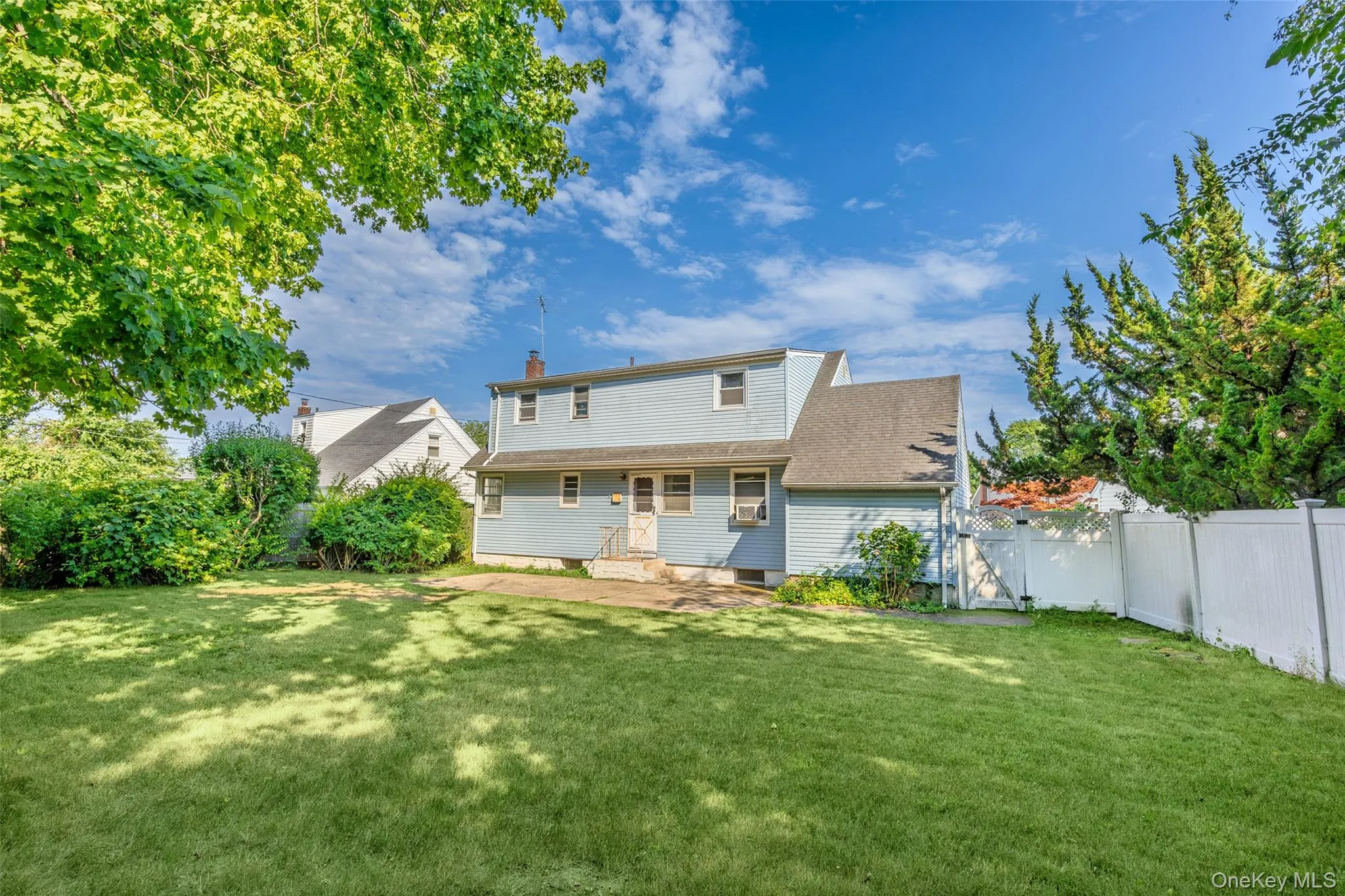 Expansive green lawn with mature perimeter landscaping and a privacy fence Expansive green lawn with mature perimeter landscaping and a privacy fence
