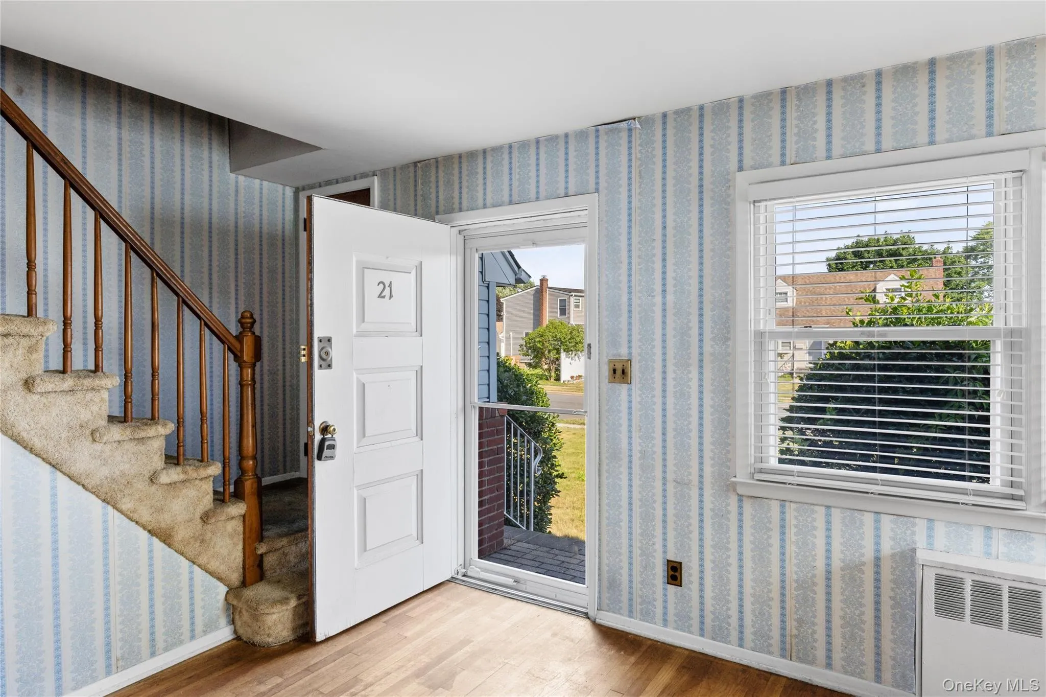 Front entry featuring hardwood flooring, a white paneled door Front entry featuring hardwood flooring, a white paneled door