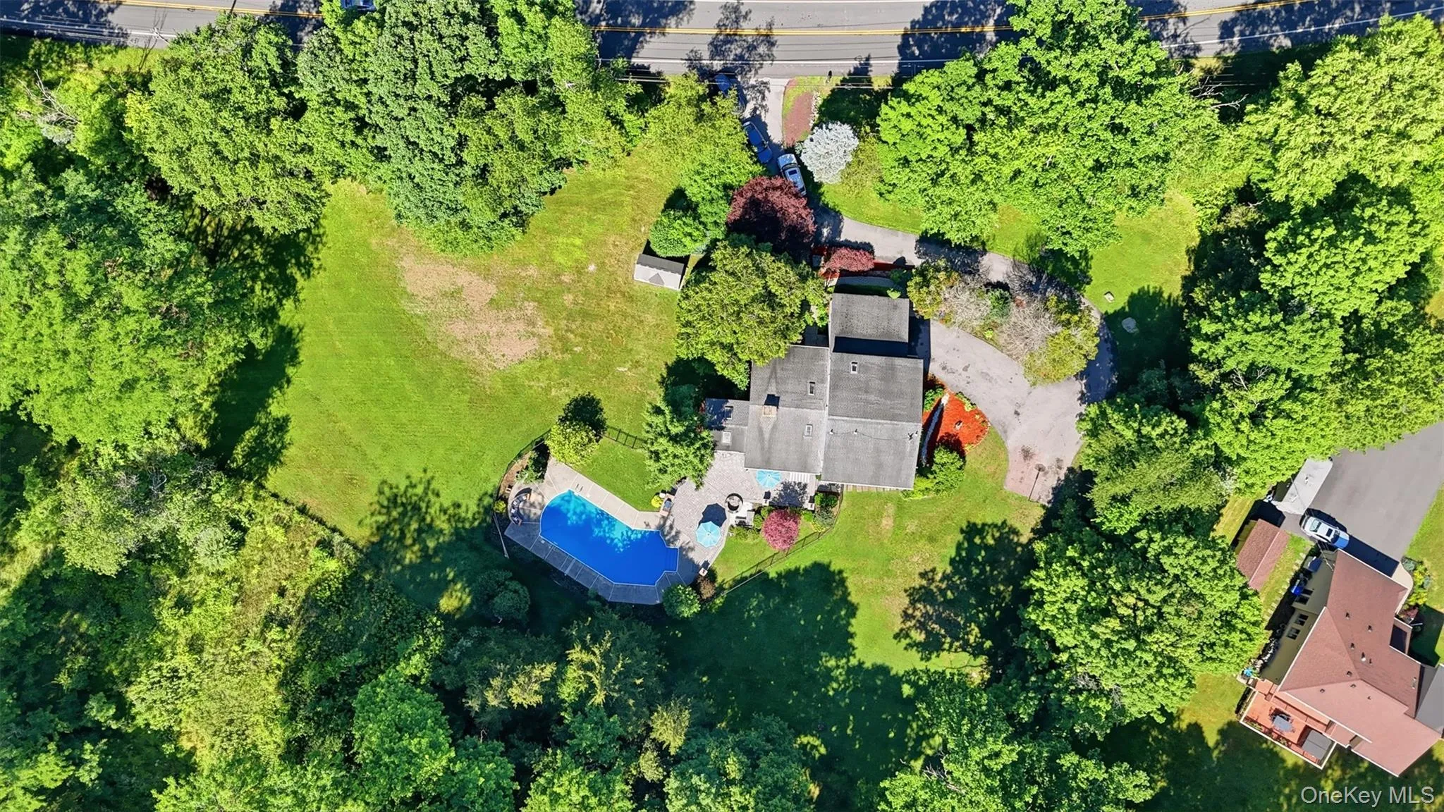 Expansive property featuring a private swimming pool, surrounding patio, and a separate outbuilding Expansive property featuring a private swimming pool, surrounding patio, and a separate outbuilding