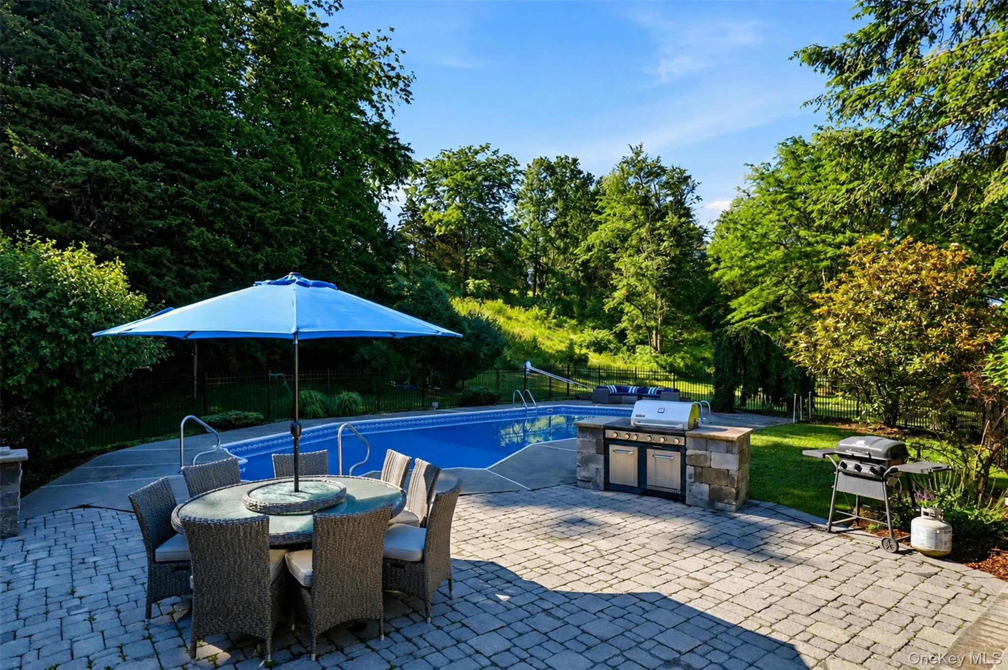 Swimming pool with surrounding concrete and paver patio Swimming pool with surrounding concrete and paver patio