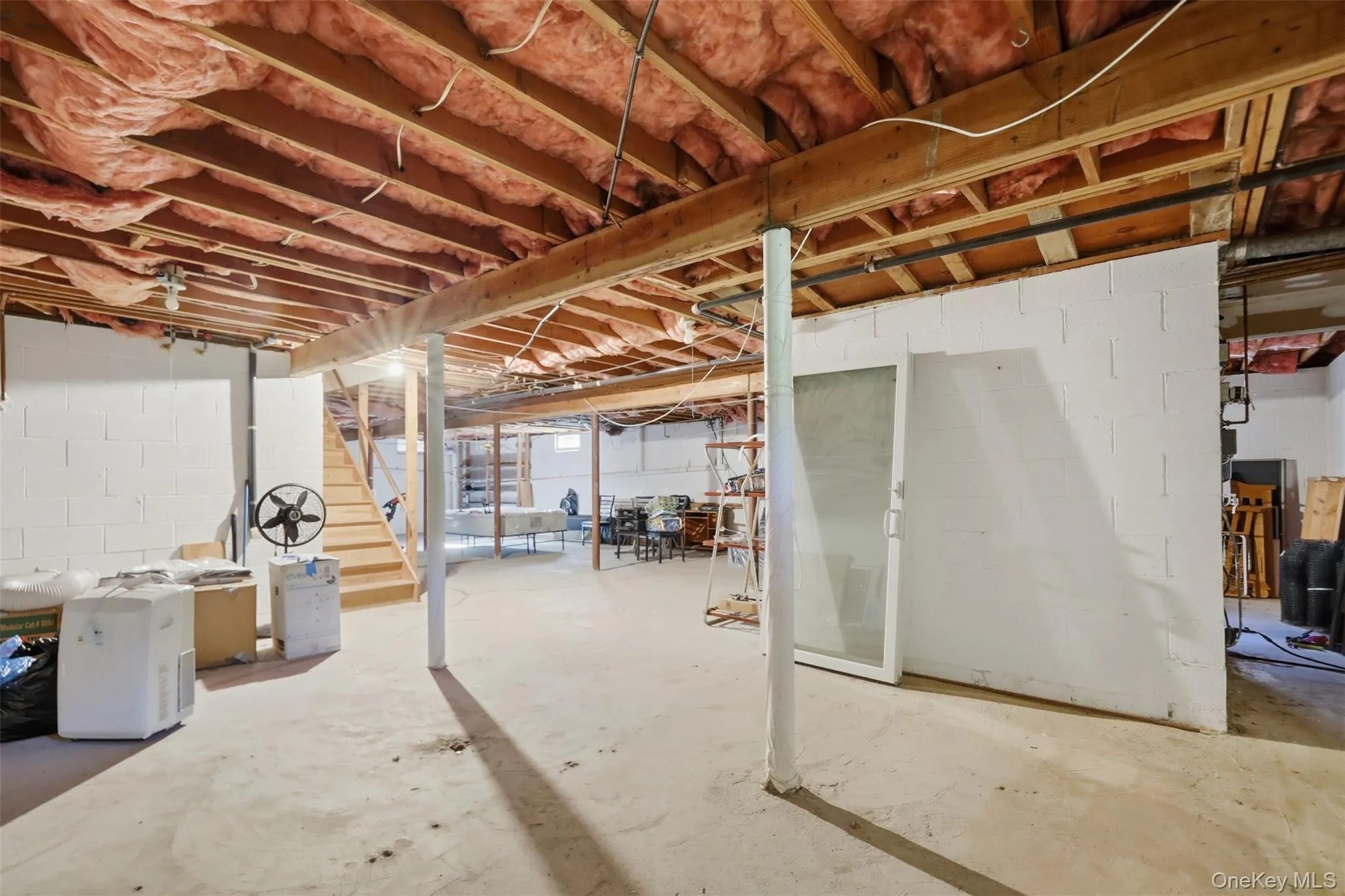 Unfinished basement with exposed ceiling joists and insulation Unfinished basement with exposed ceiling joists and insulation