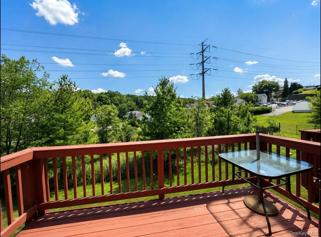 Expansive outdoor deck with red-stained wood flooring and matching railings Expansive outdoor deck with red-stained wood flooring and matching railings