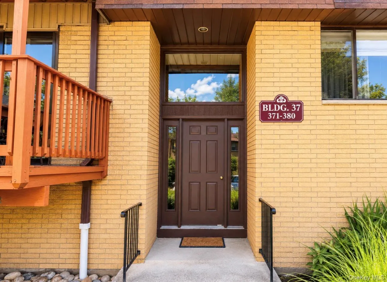 Building entry featuring a paneled brown door with sidelights and a transom window Building entry featuring a paneled brown door with sidelights and a transom window