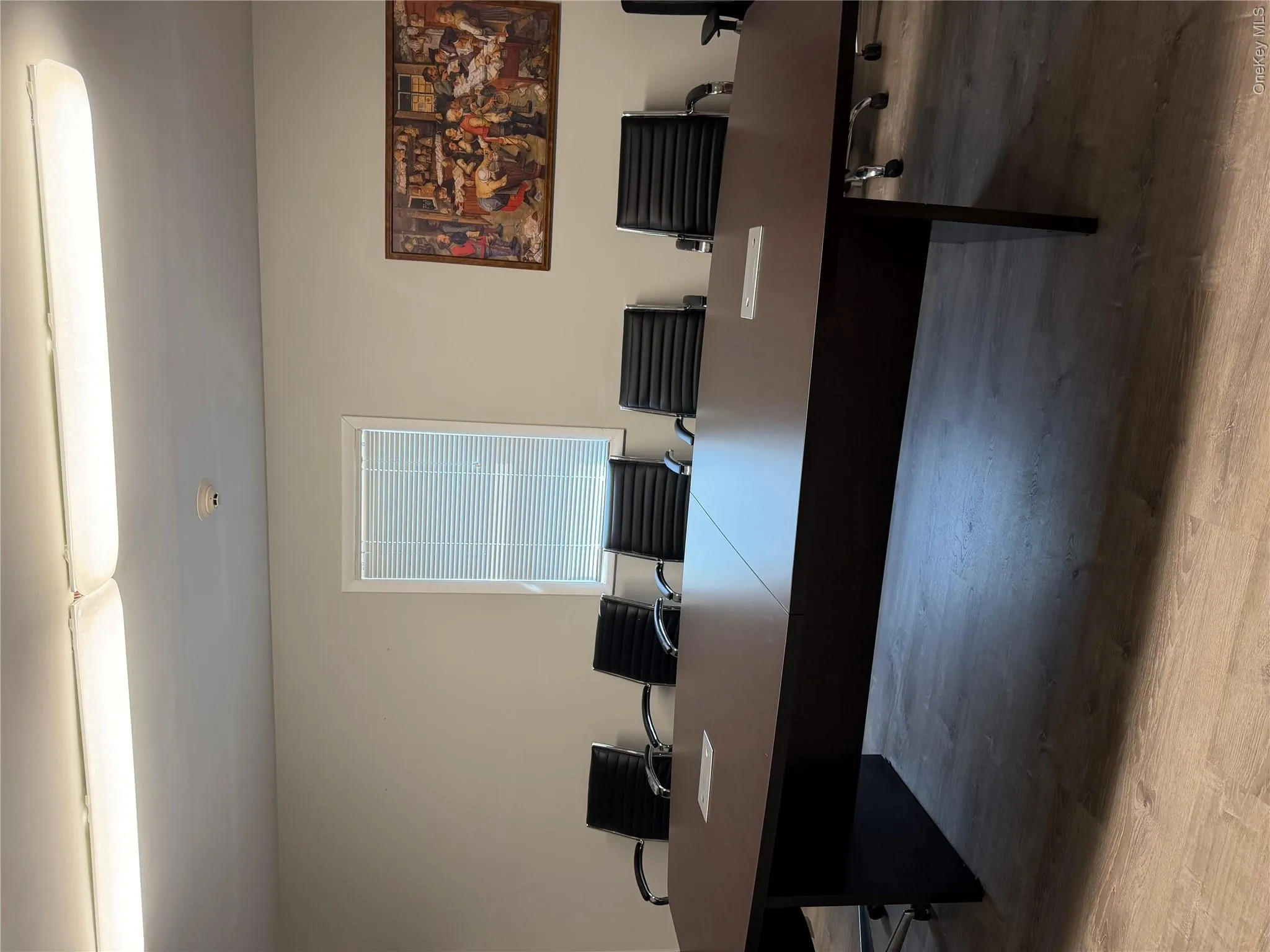 Spacious room with wood-finish flooring, a large conference table, and ample overhead lighting Spacious room with wood-finish flooring, a large conference table, and ample overhead lighting